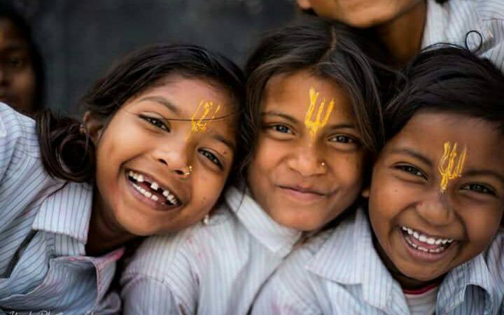 Three children jumping in burlap sacks during a race.