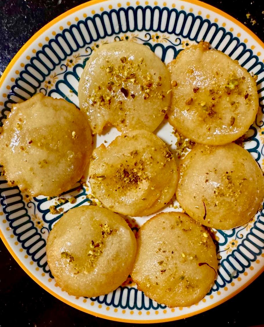 Pakatlya Purya - sweet flaky puris, garnished with pista and saffron, served in a plate