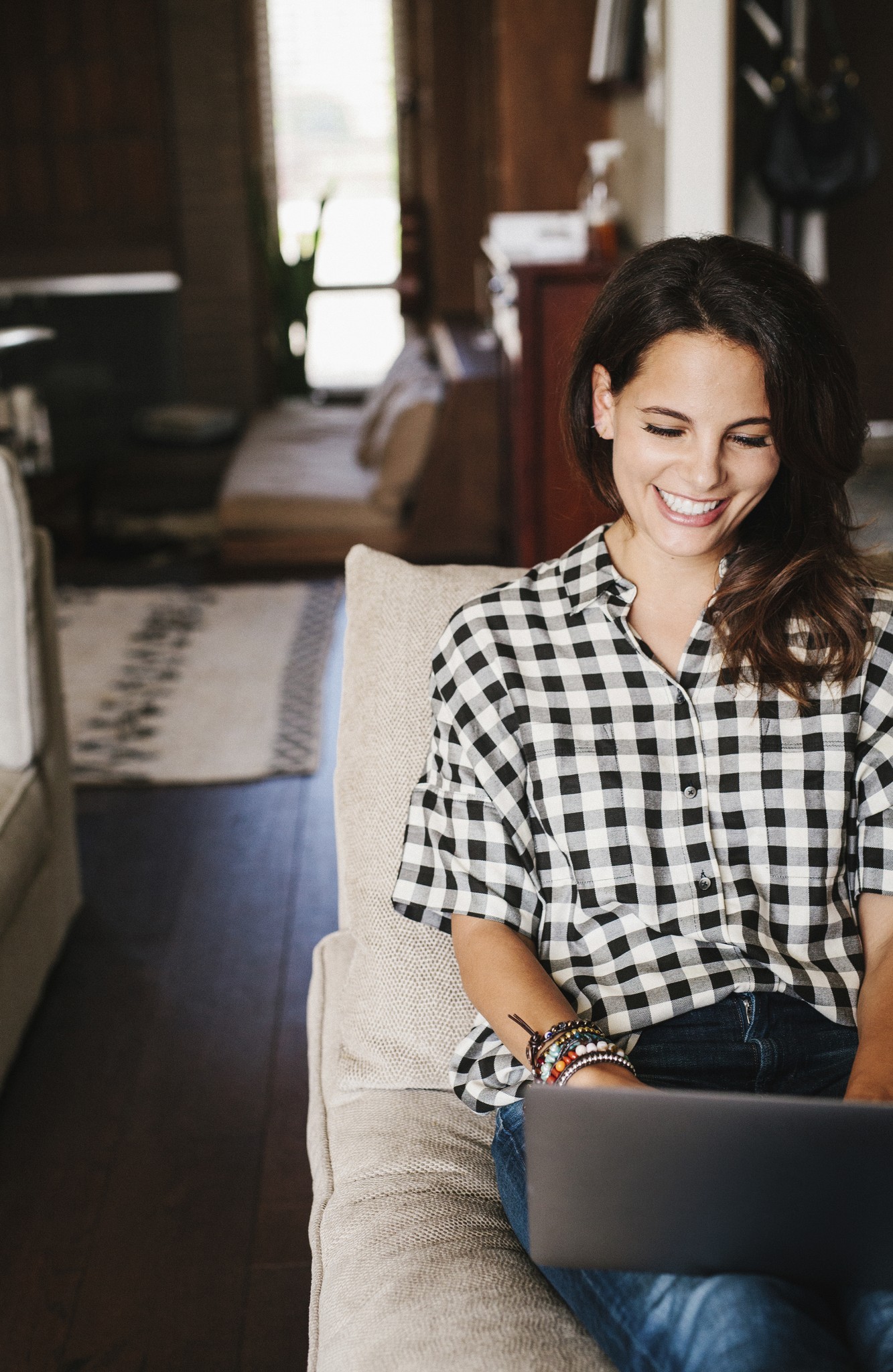 Smiling Woman Works on Laptop at Home