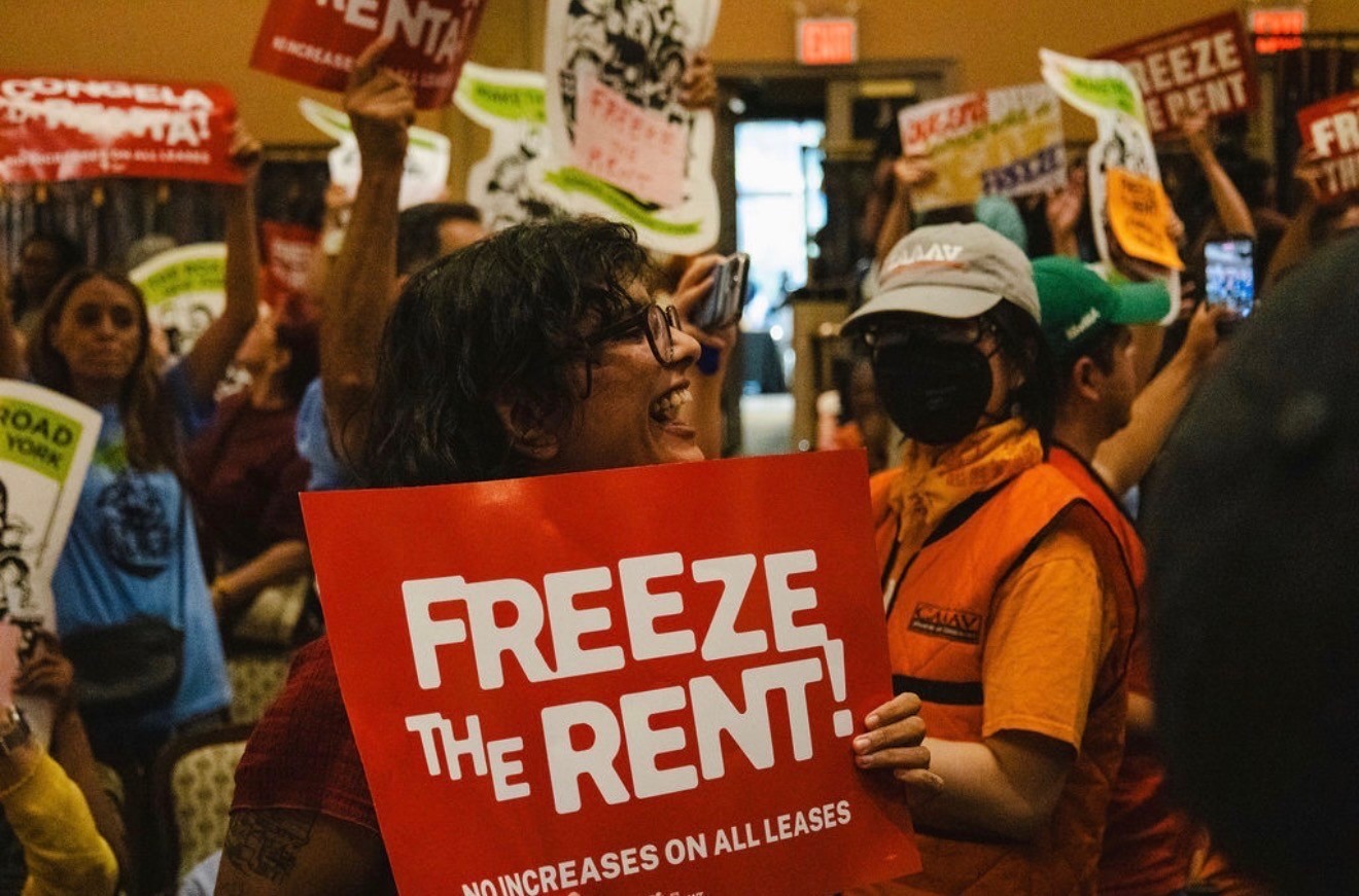 Ritti Singh holding a Freeze the Rent sign at a tenant rally