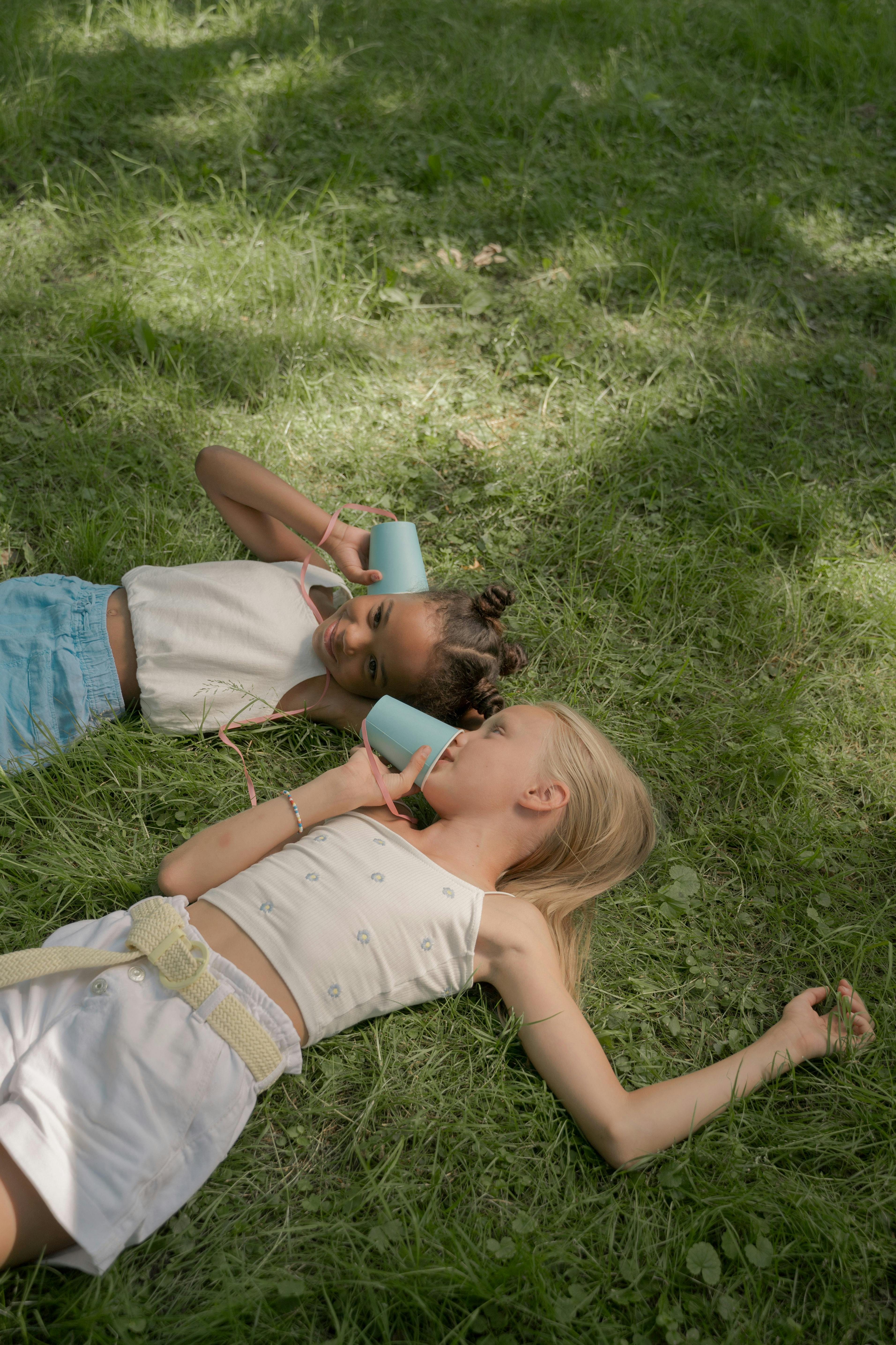 kids lying on a glass land and smiling