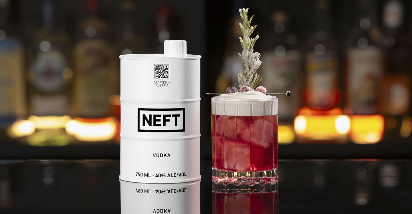 A NEFT Barrel and a glass of Cranberry Whip on a bar counter.