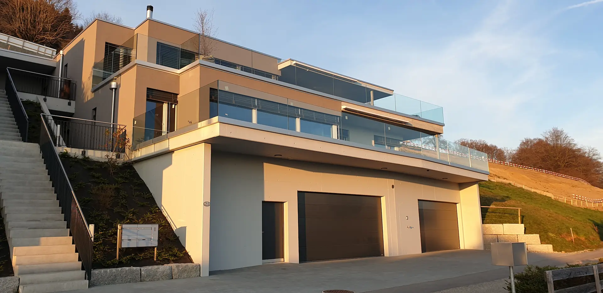 Modernes Mehrfamilienhaus mit Terrassenwohnungen im Abendlicht
