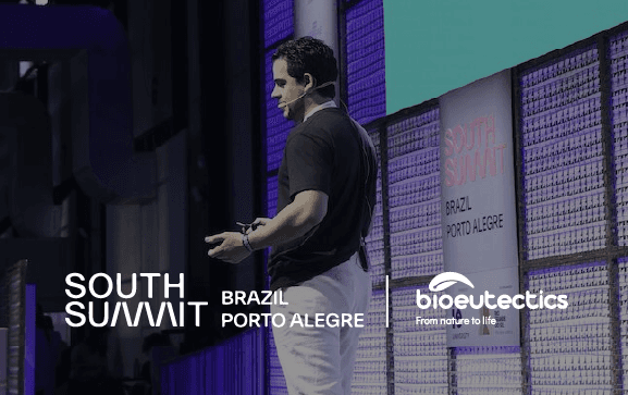 Member team of bioeutectics speaking at a conference on stage.