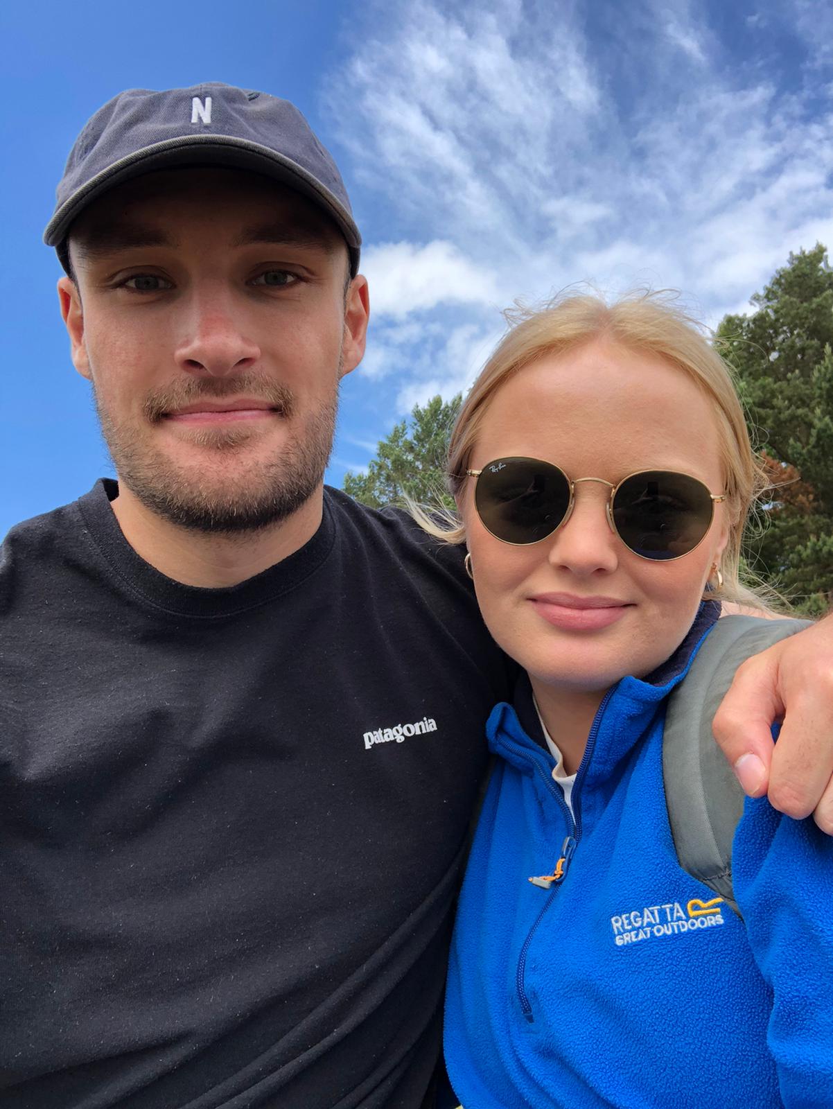 A woman in jeans jacket, holding a camera.