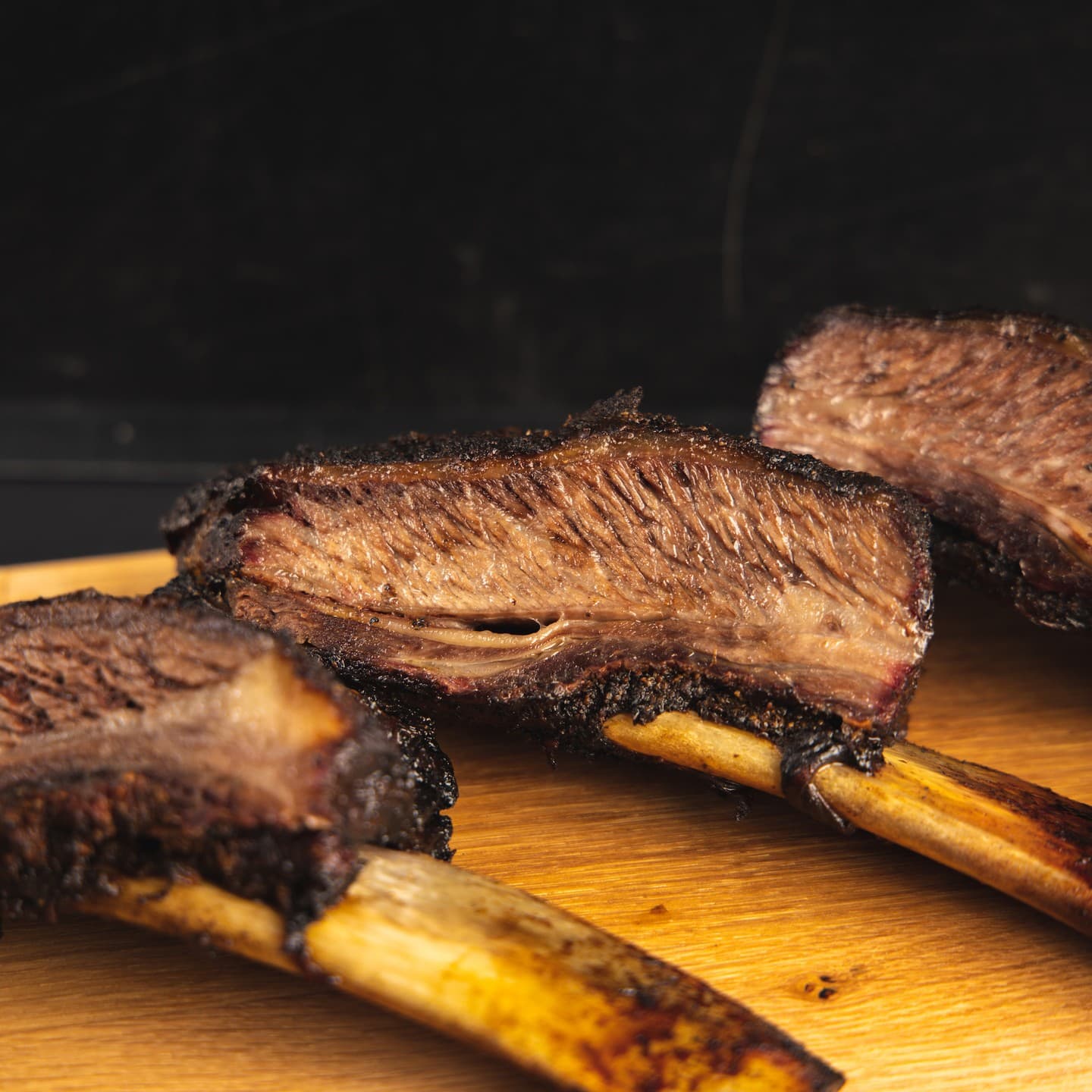 Close-up of Texas BBQ ribs showing juicy, tender meat with rich smoky glaze, highlighting slow-cooked texture and savoury flavour.