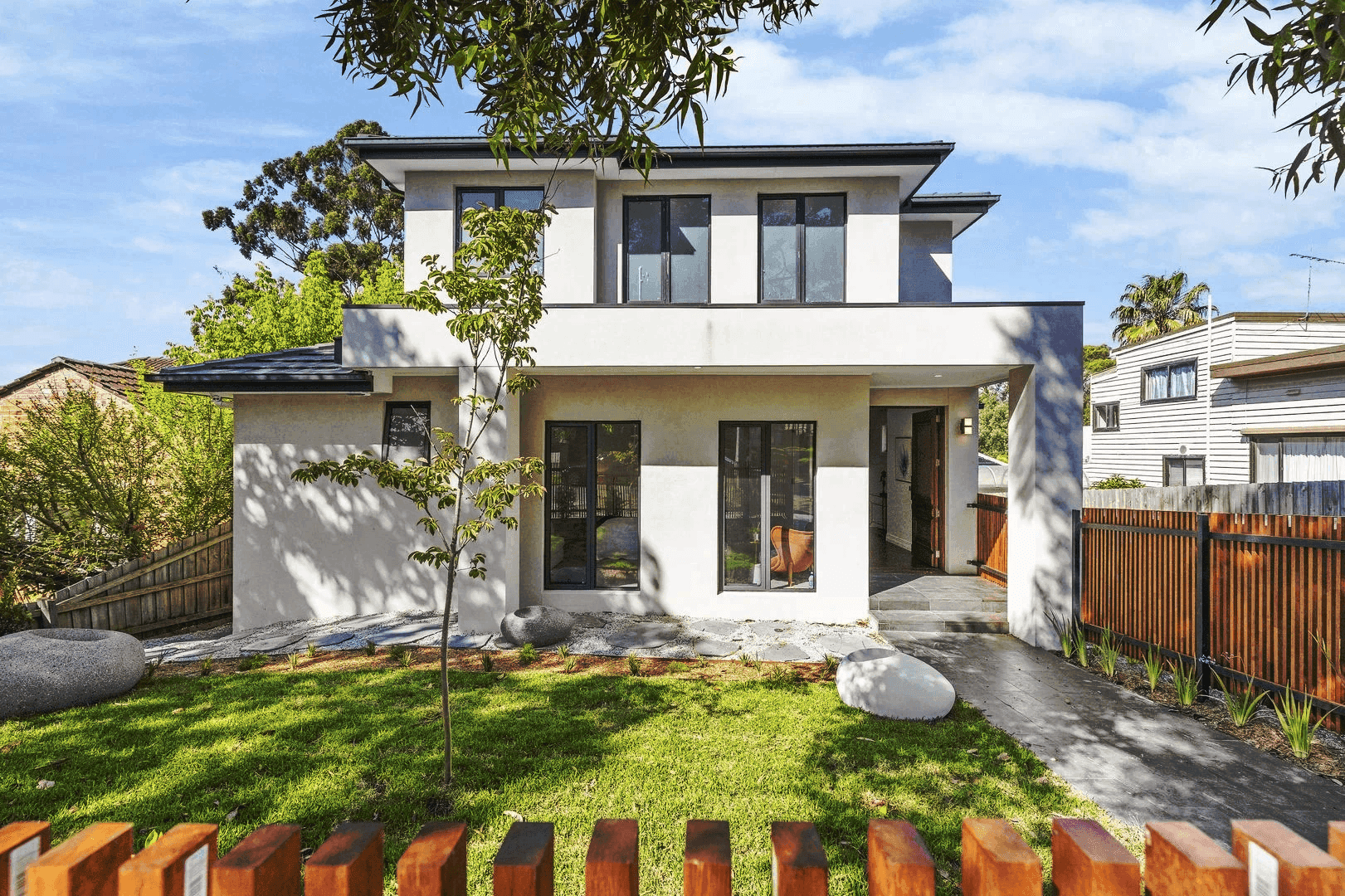 A modern elevator lobby with wooden walls and a plant