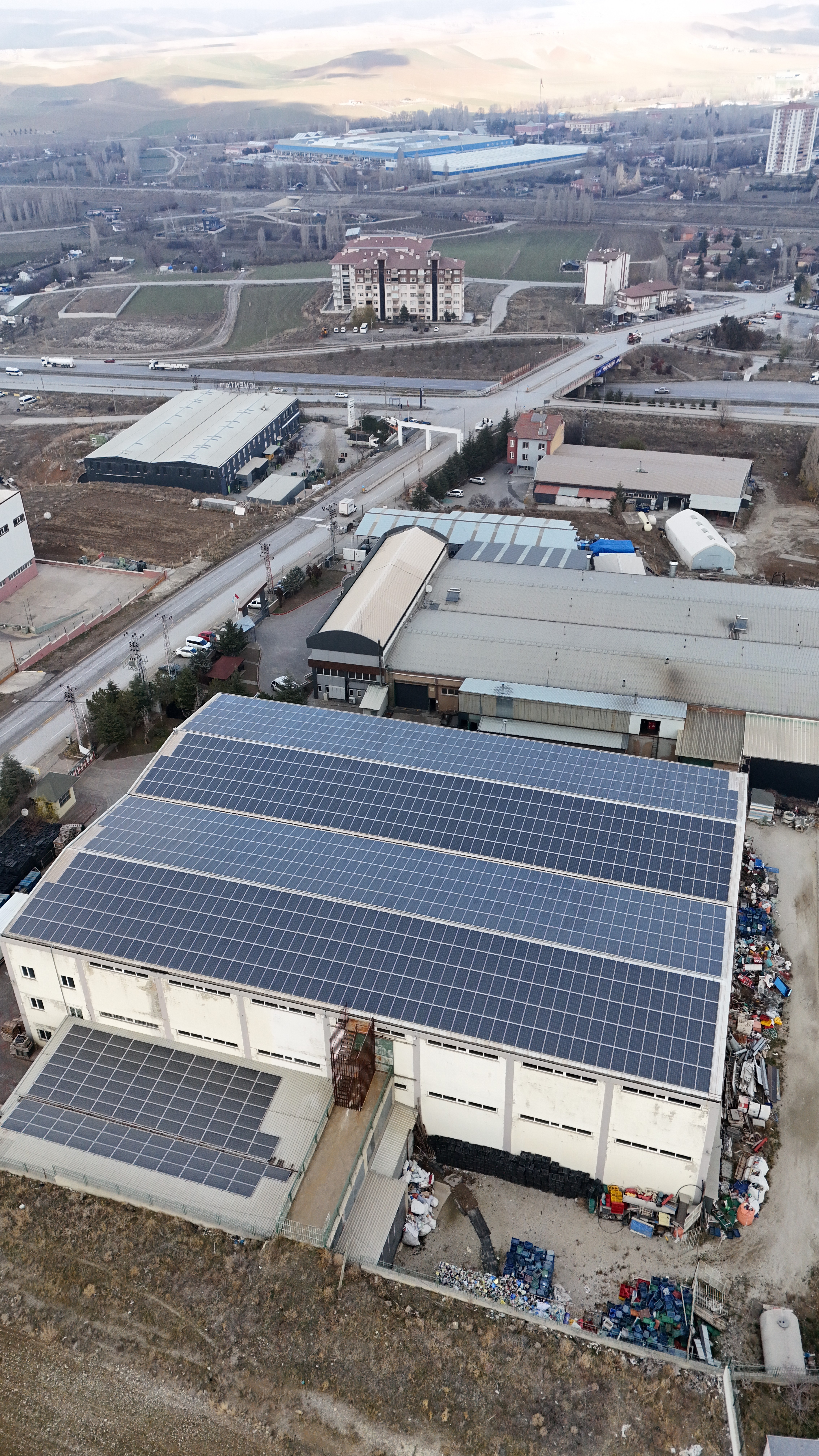 A sophisticated lounge terrace with curved white stucco walls, stone seating, and arched cutouts perfectly framing an unobstructed ocean sunset.
