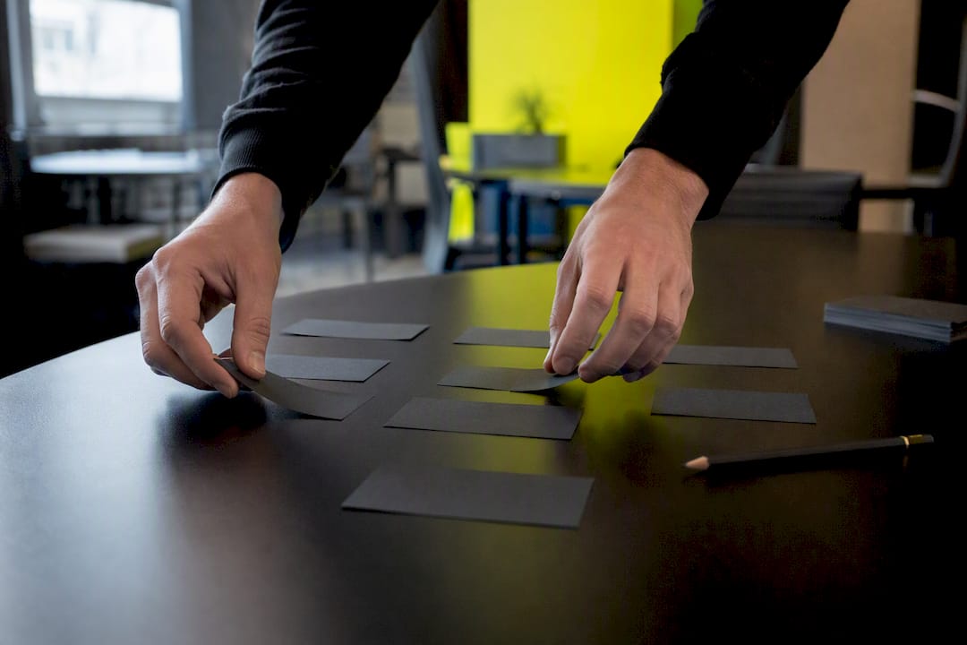 Hands arranging cards representing lead scoring