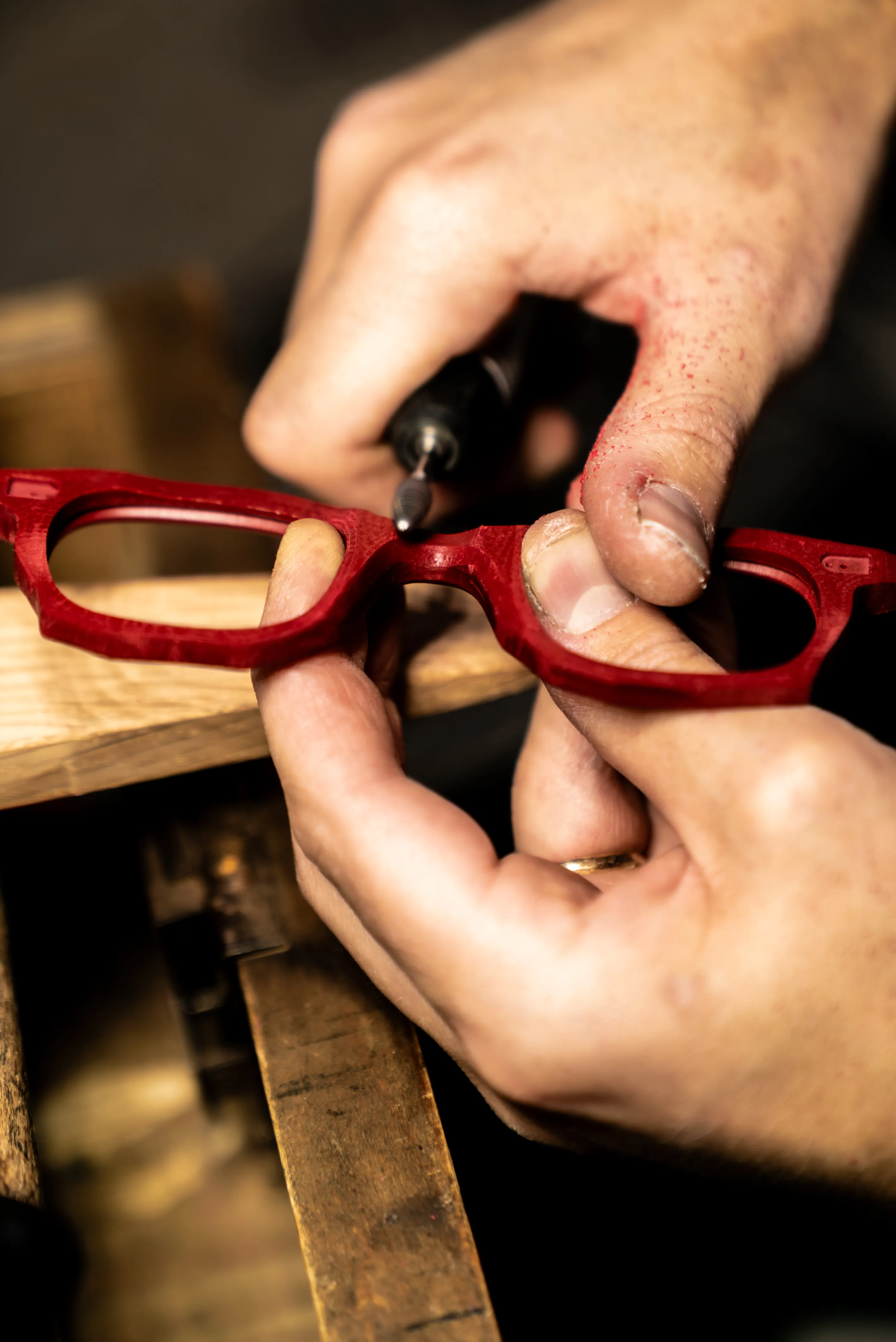 Lavorazione manuale di una montatura rossa IDIA durante una fase di definizione e rifinitura dell’occhiale. La fotografia racconta il principio degli occhiali su misura IDIA di Ottica Dentella ad Ancona: ogni montatura nasce da misure precise del viso, studio delle proporzioni e progettazione individuale, per trasformare il disegno in un occhiale costruito sulle caratteristiche anatomiche e sull’identità della persona.