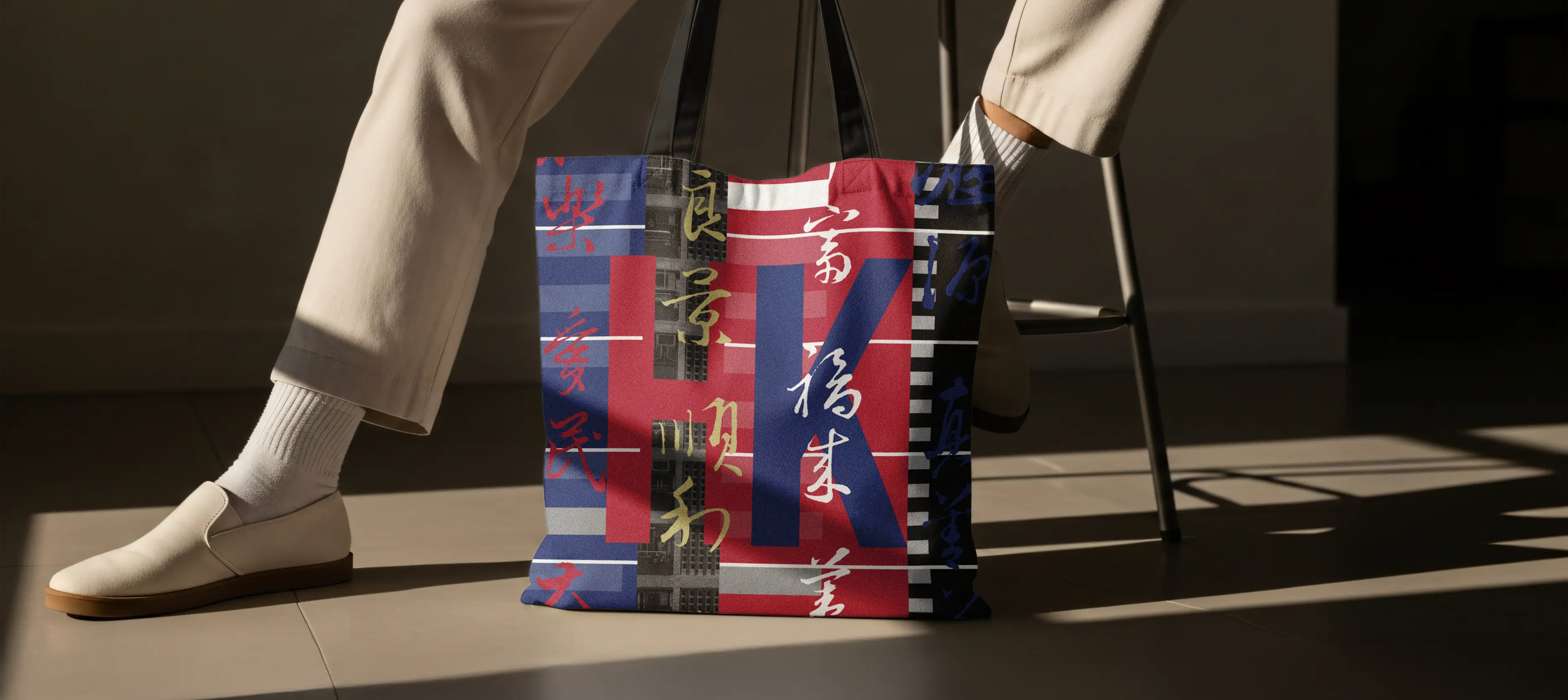 HK Public Housing visual identity application – canvas tote bag with bold orange-red and blue estate typography and high-rise building photographs, evoking community warmth and belonging by Teatime Studio.