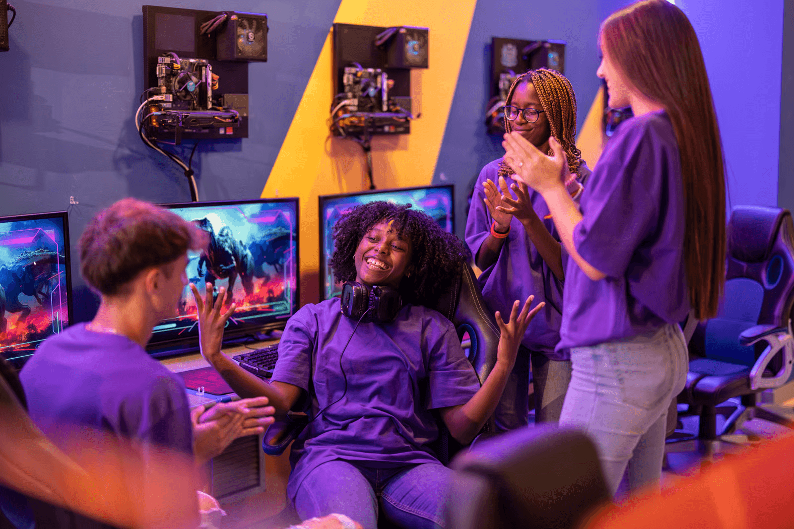 A group of students celebrating a teammate after a successful gaming session at a computer gaming lab.