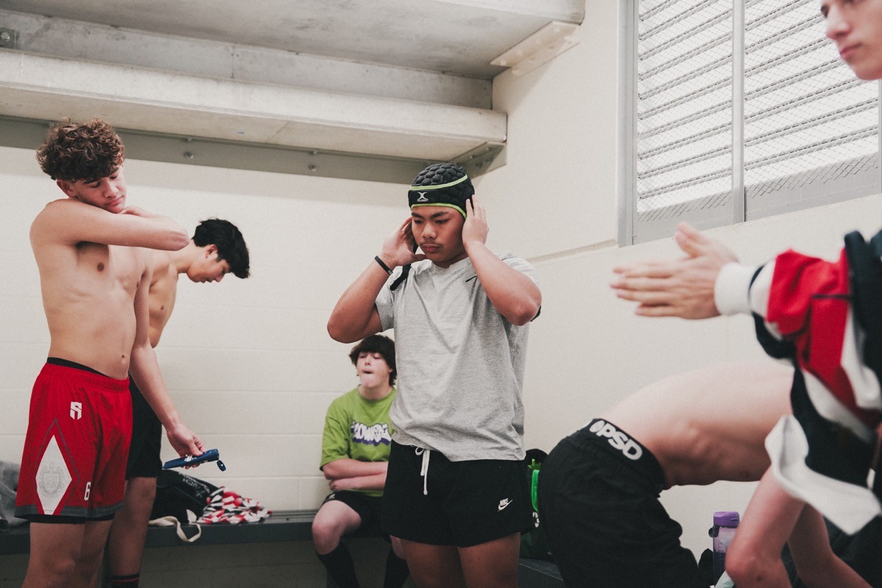 rugby players in a locker room getting ready for a game