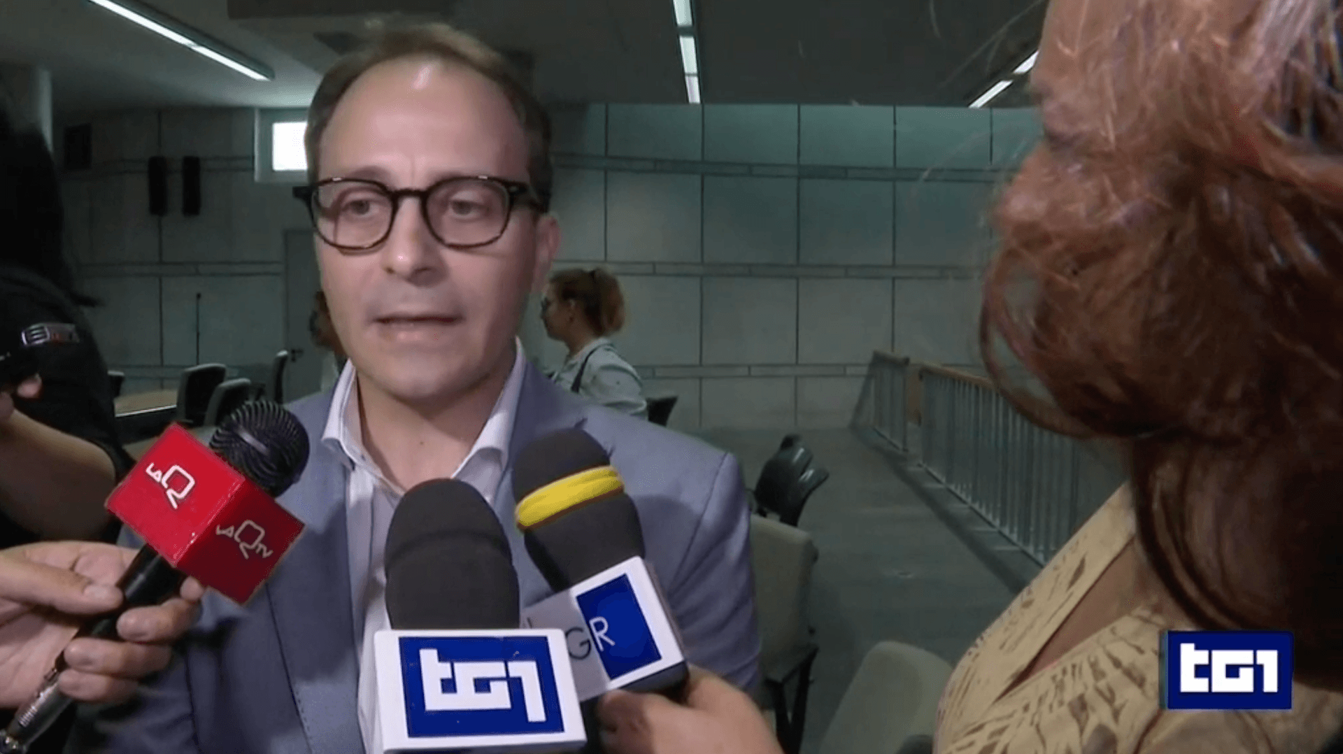 Scientist wearing safety goggles and blue lab attire, using a pipette to transfer liquid into a vial in a laboratory setting.
