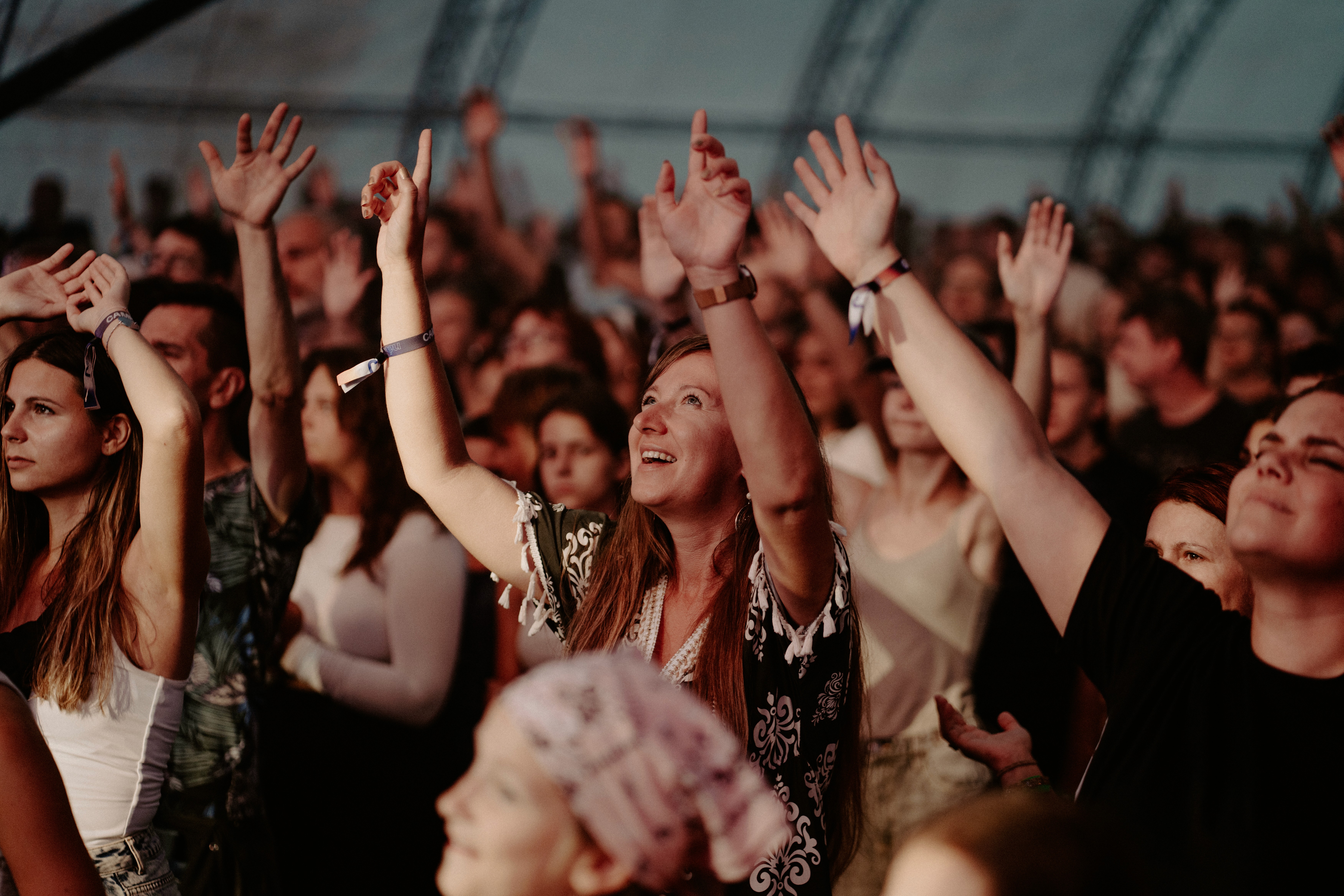 Lively crowd raising their hands toward a stage