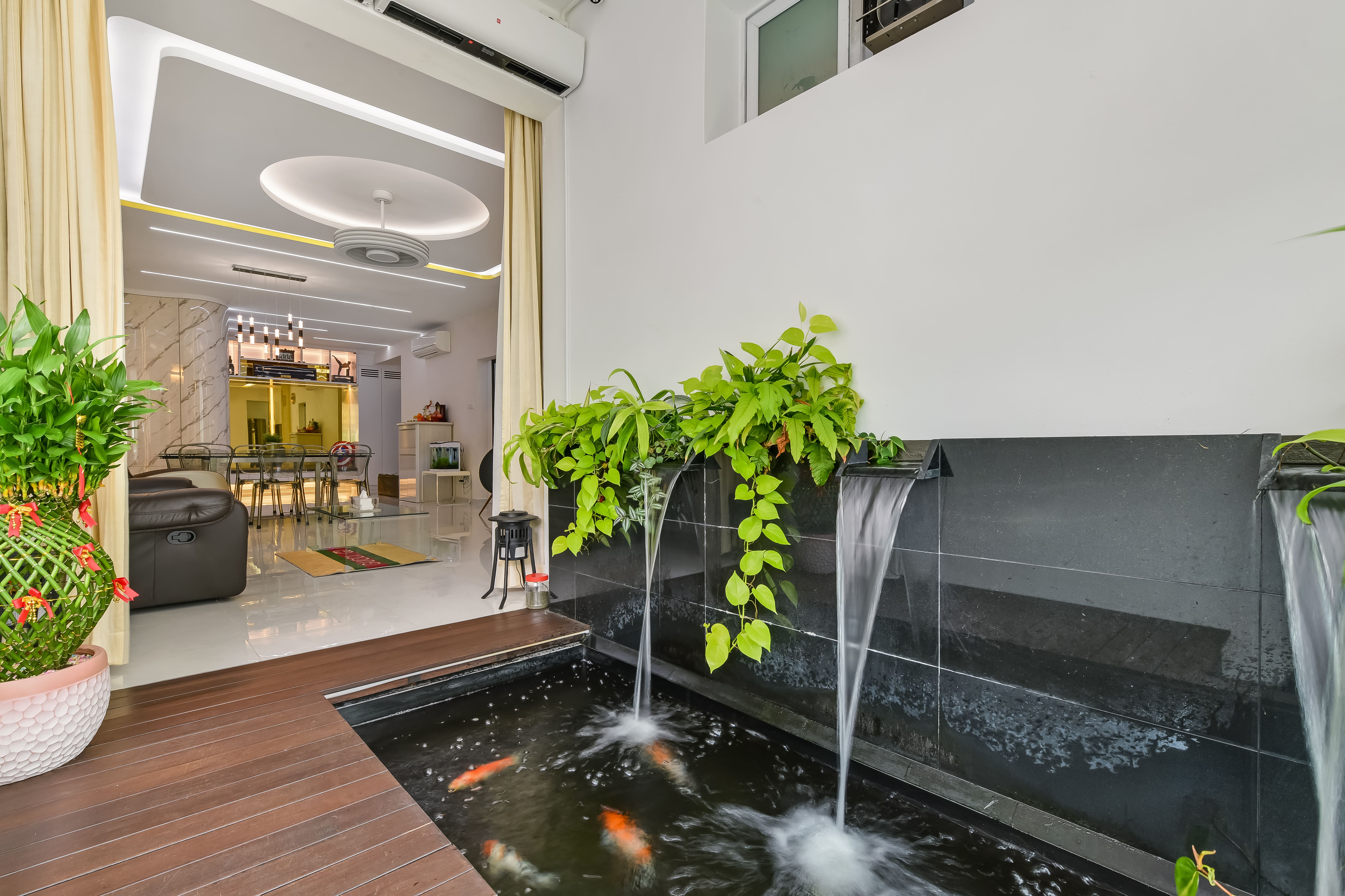koi pond with cascading water features, framed by lush greenery, creating a tranquil transition between outdoor and indoor living.