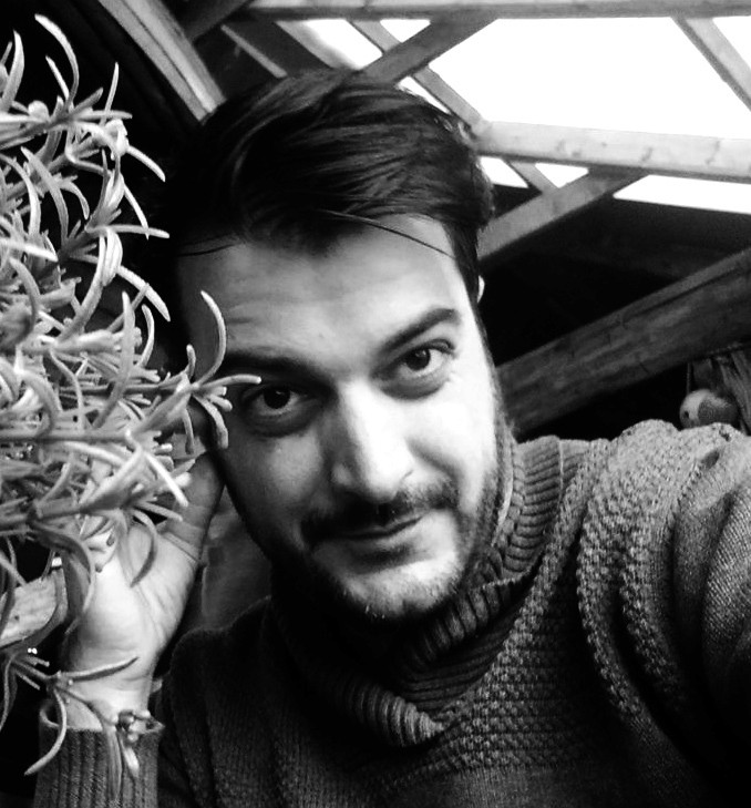 A smiling woman writing on a piece of paper in her home