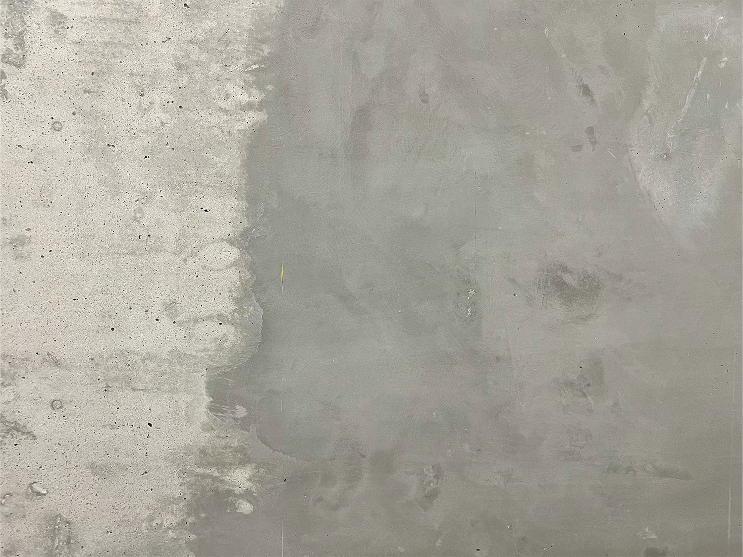 Strukturierte Betonwand. Die Oberseite ist hell, die Unterseite dunkler und schattiert.
