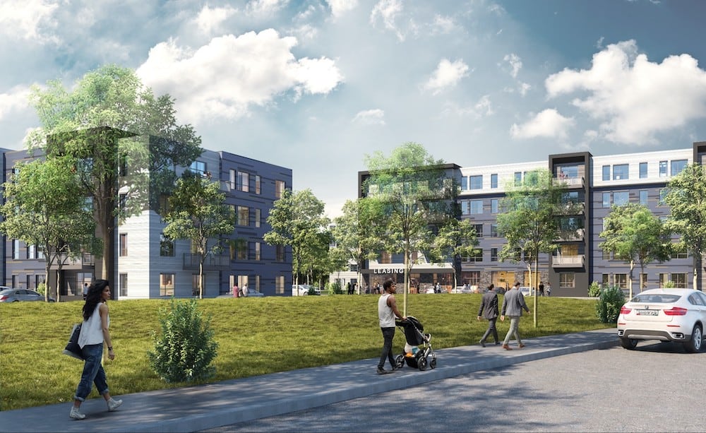 Street-level view of contemporary grey and white apartment buildings with landscaped lawns and pedestrians, representing a completed residential project secured by M-Fire.