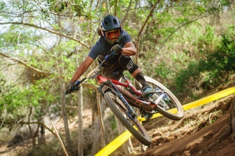 four boys laughing and sitting on grass during daytime