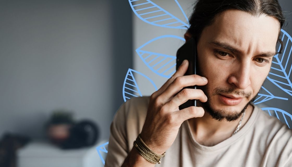 Man with dark hair on a cell phone looking tense