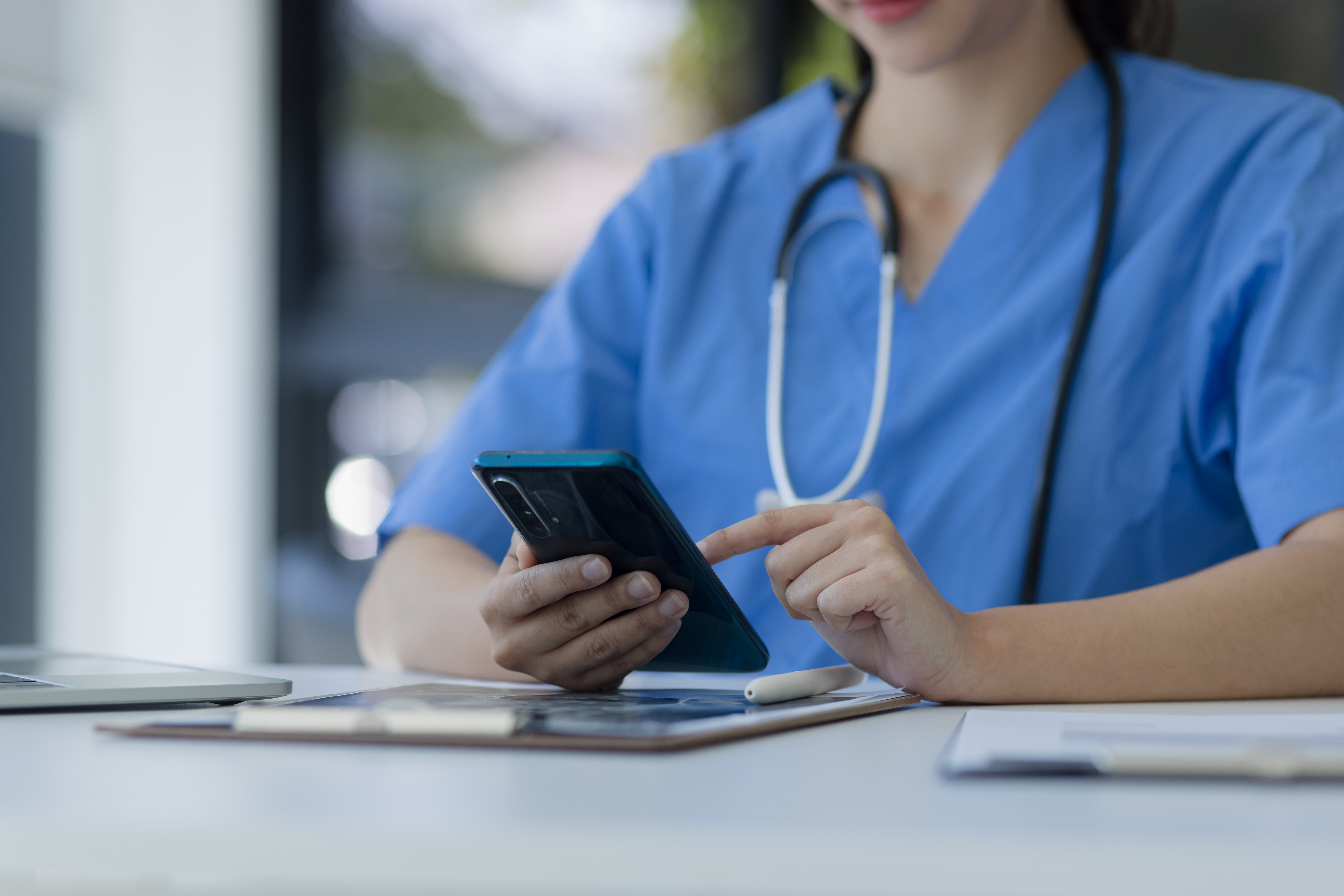 veterinarian using cell phone while looking at a chart