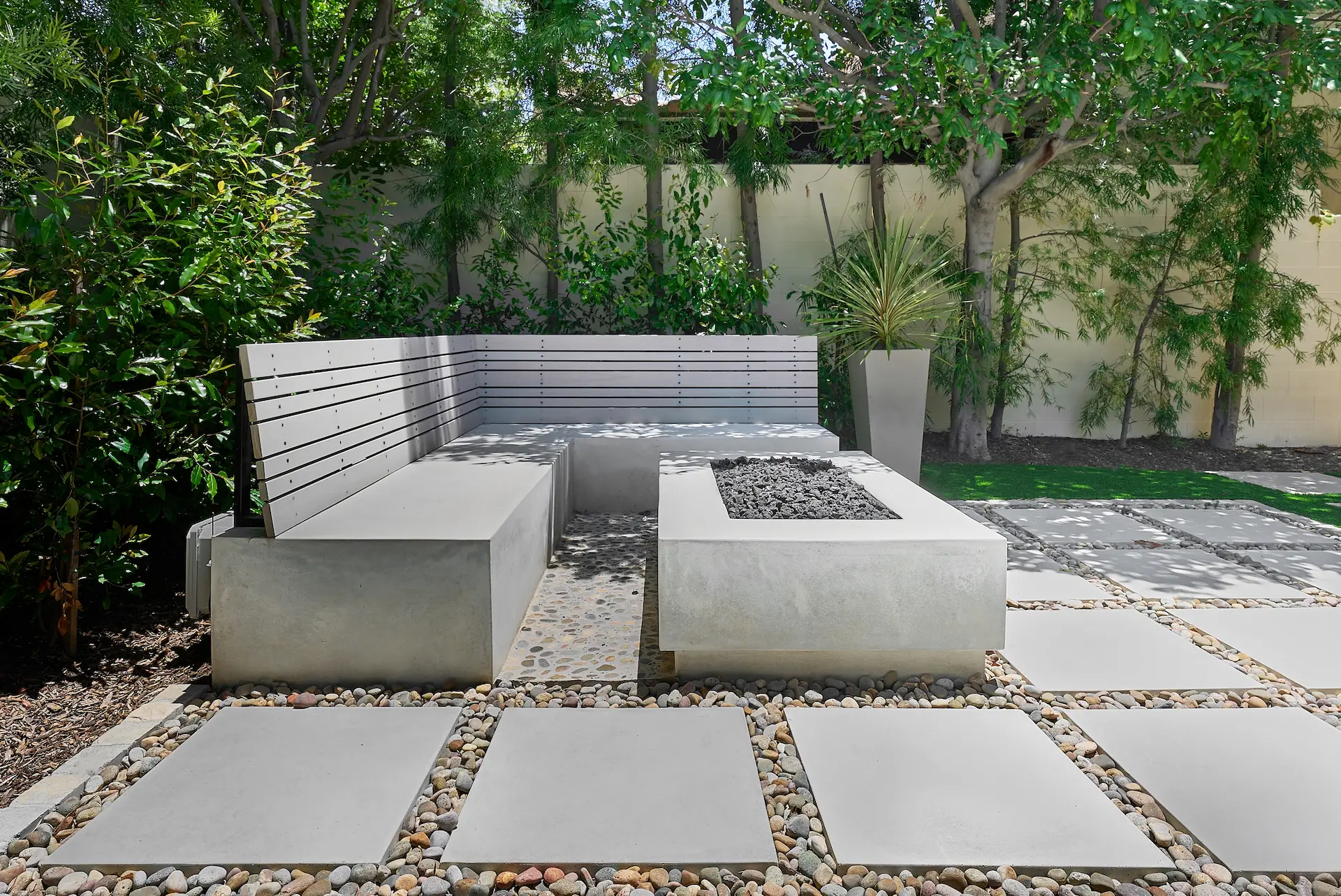 View of the exterior hardscape, featuring firepit and seating area in the Irvine Contemporary Coastal Remodel. Photo by Todd Huge.
