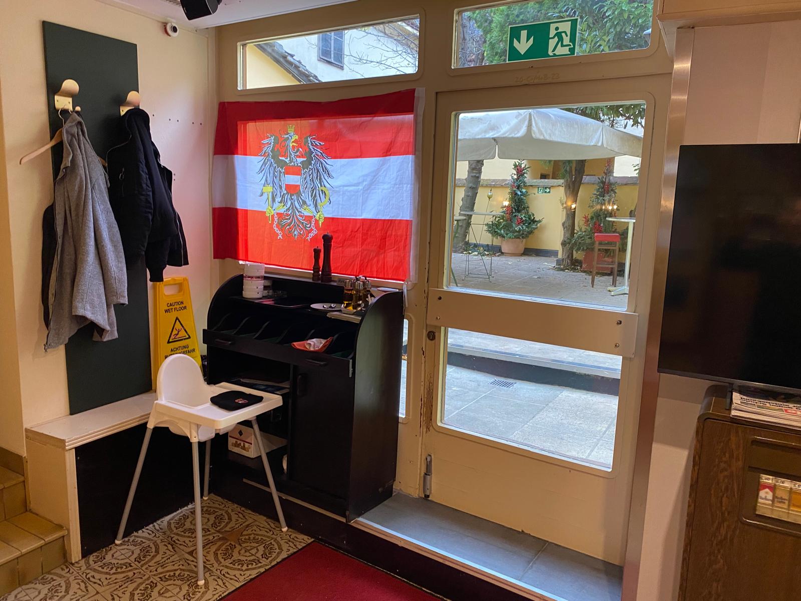 Person wearing a beige apron whisking green matcha tea in a ceramic bowl on a kitchen counter.