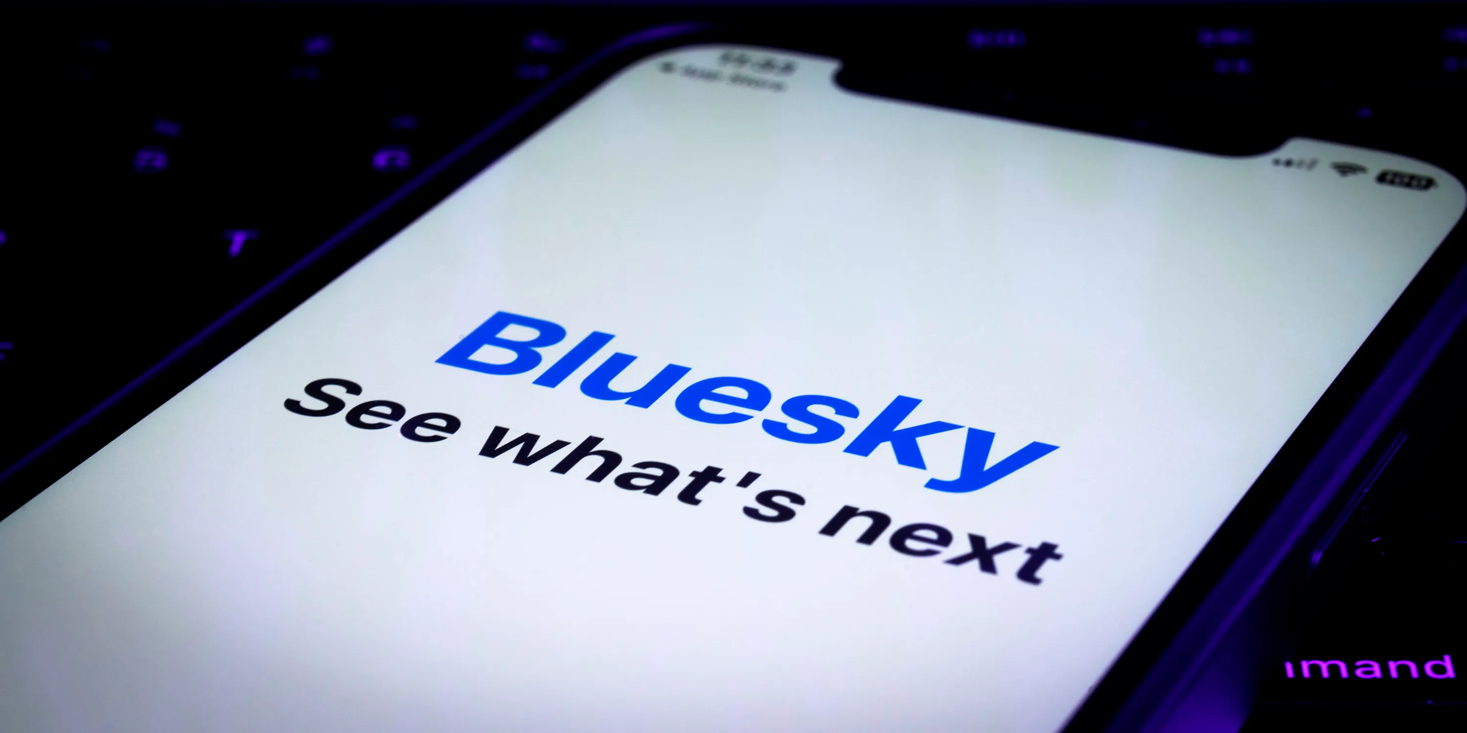 A phone screen shows the Bluesky Social app and a text underneath saying “See what’s next.” 