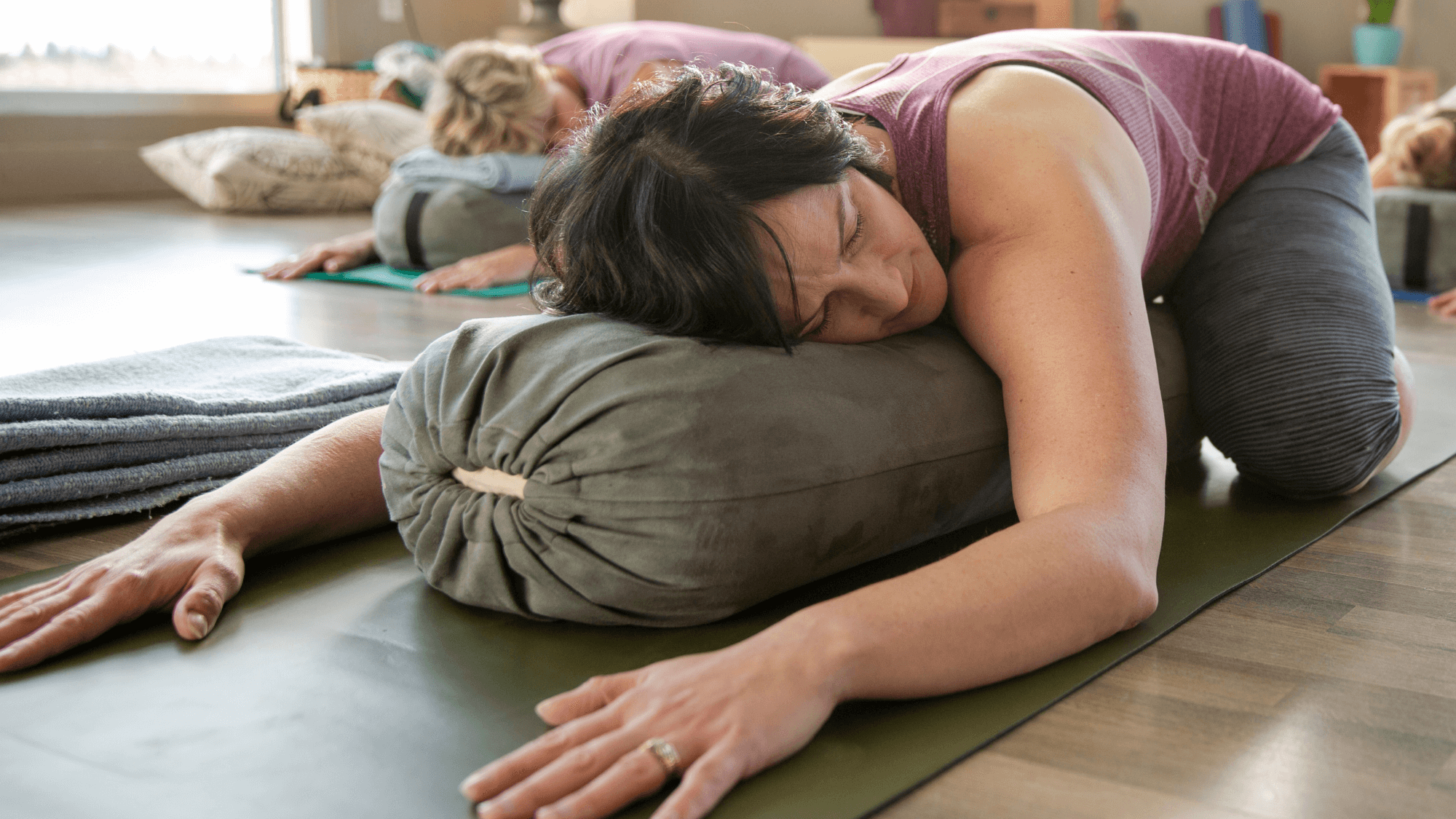 Lady in restorative childs pose in a menopause yoga class