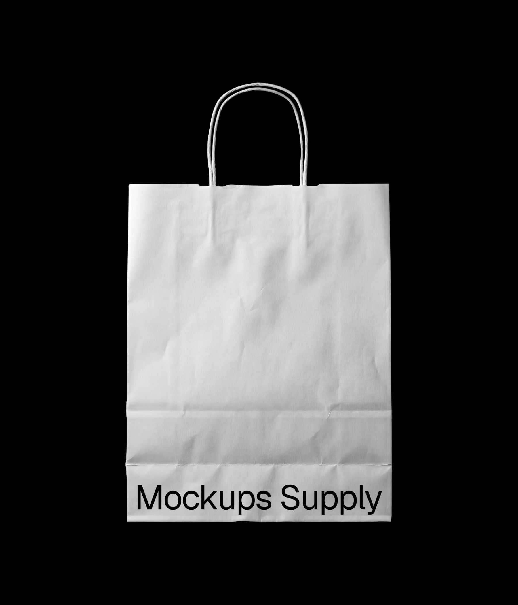 Crumpled paper shopping bag mockup with twisted handle resting on a clean studio surface