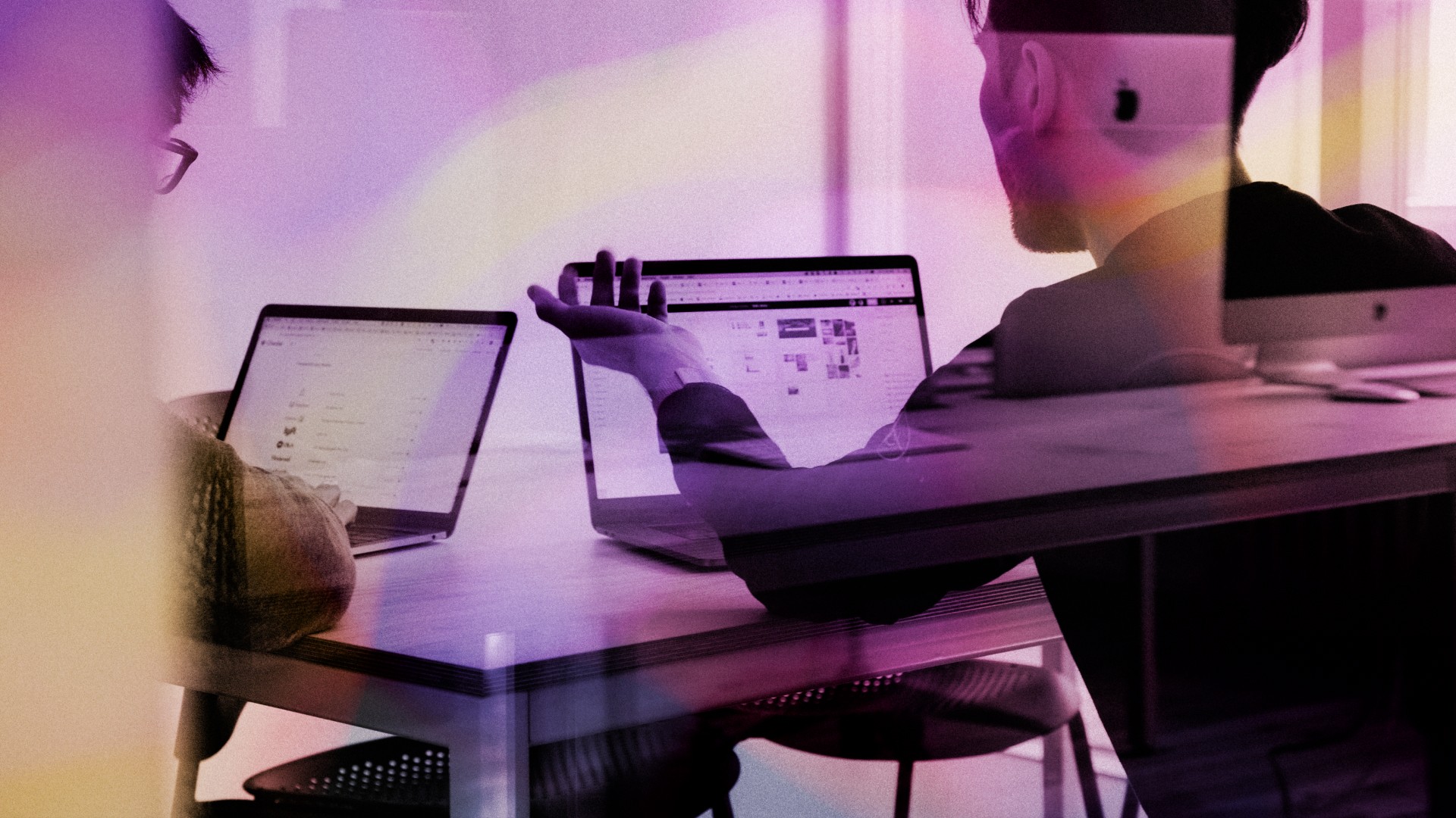 A person gestures at their laptop while making a point