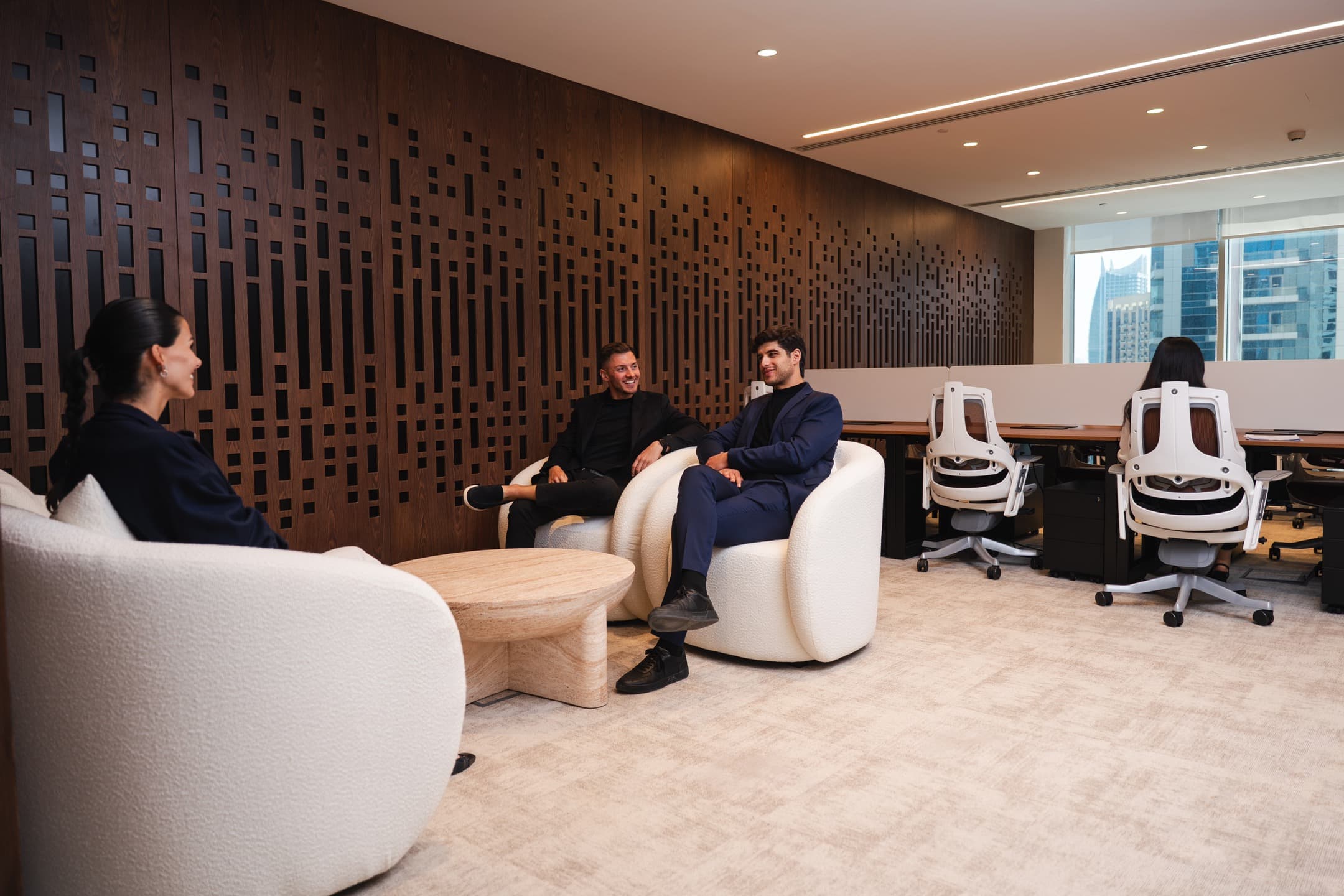 Shared lounge and pantry area with green seating, open coffee station, and a blend of social and workspaces.