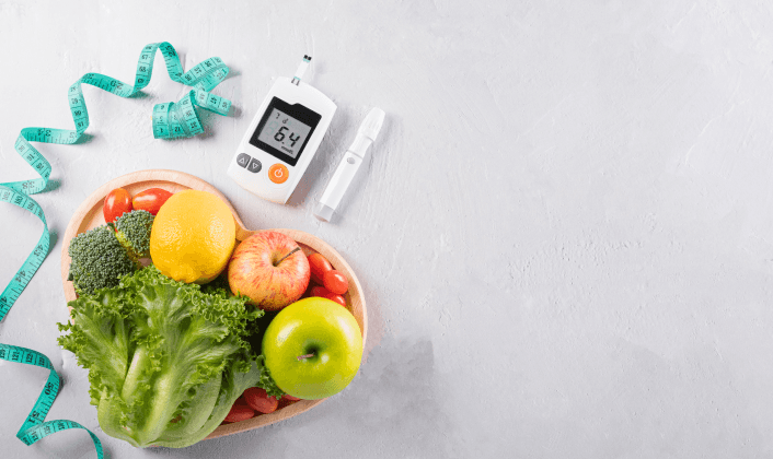 Healthy food with glucose monitor and measuring tape on table.