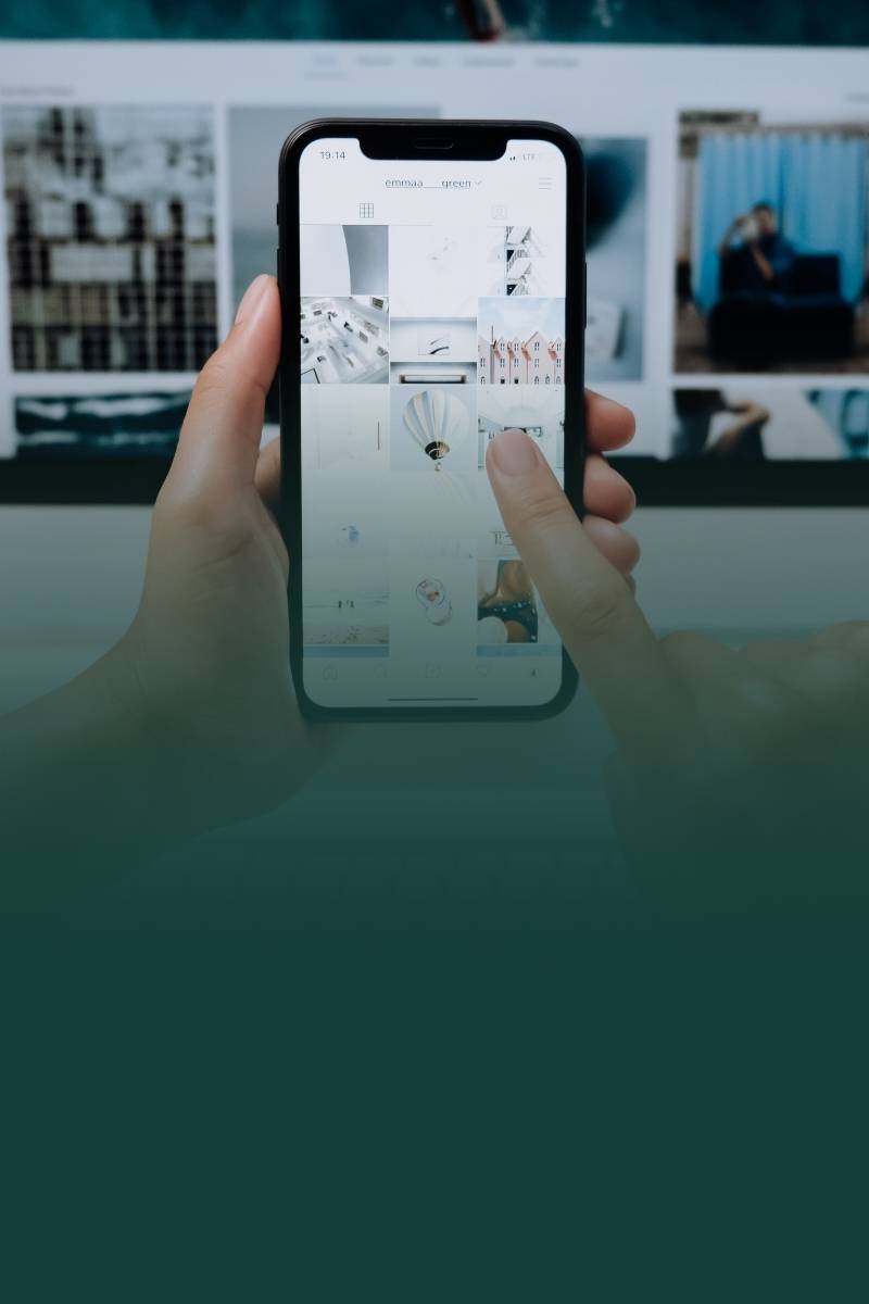 An image showing a hand holding a phone. Demonstrating social media and graphic design for a digital marketing.