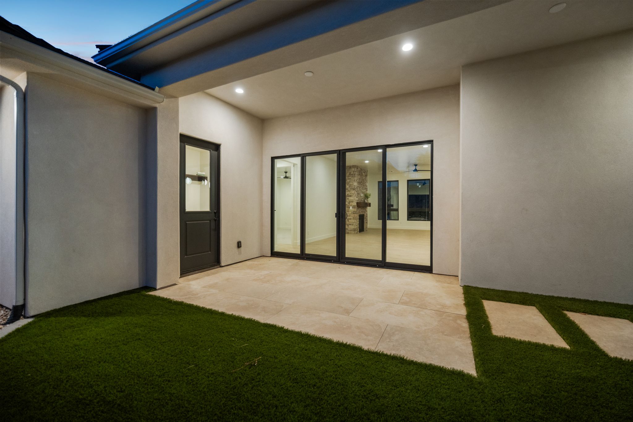 Back exterior of The Overlook at Falcon Ridge highlighting large sliding doors and outdoor entertaining space in Hurricane, Utah.
