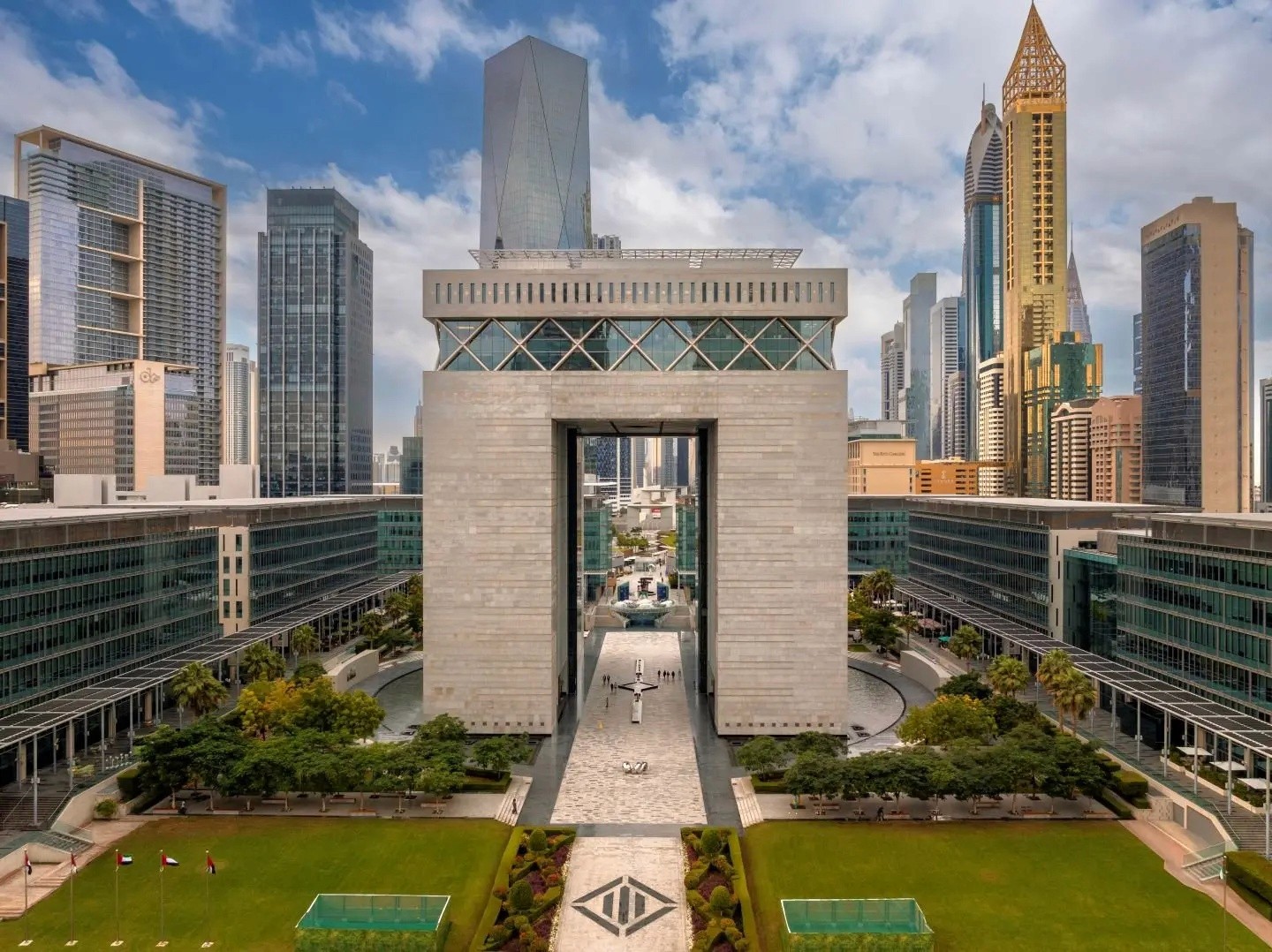 The DIFC Gate Building in Dubai framed by modern skyscrapers and green gardens.&nbsp;