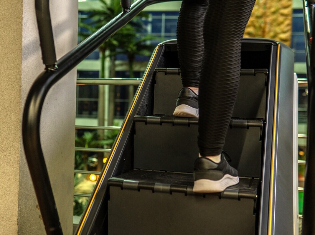 legs of a woman at the gym using a StairMaster to complement her weight loss treadmill workouts