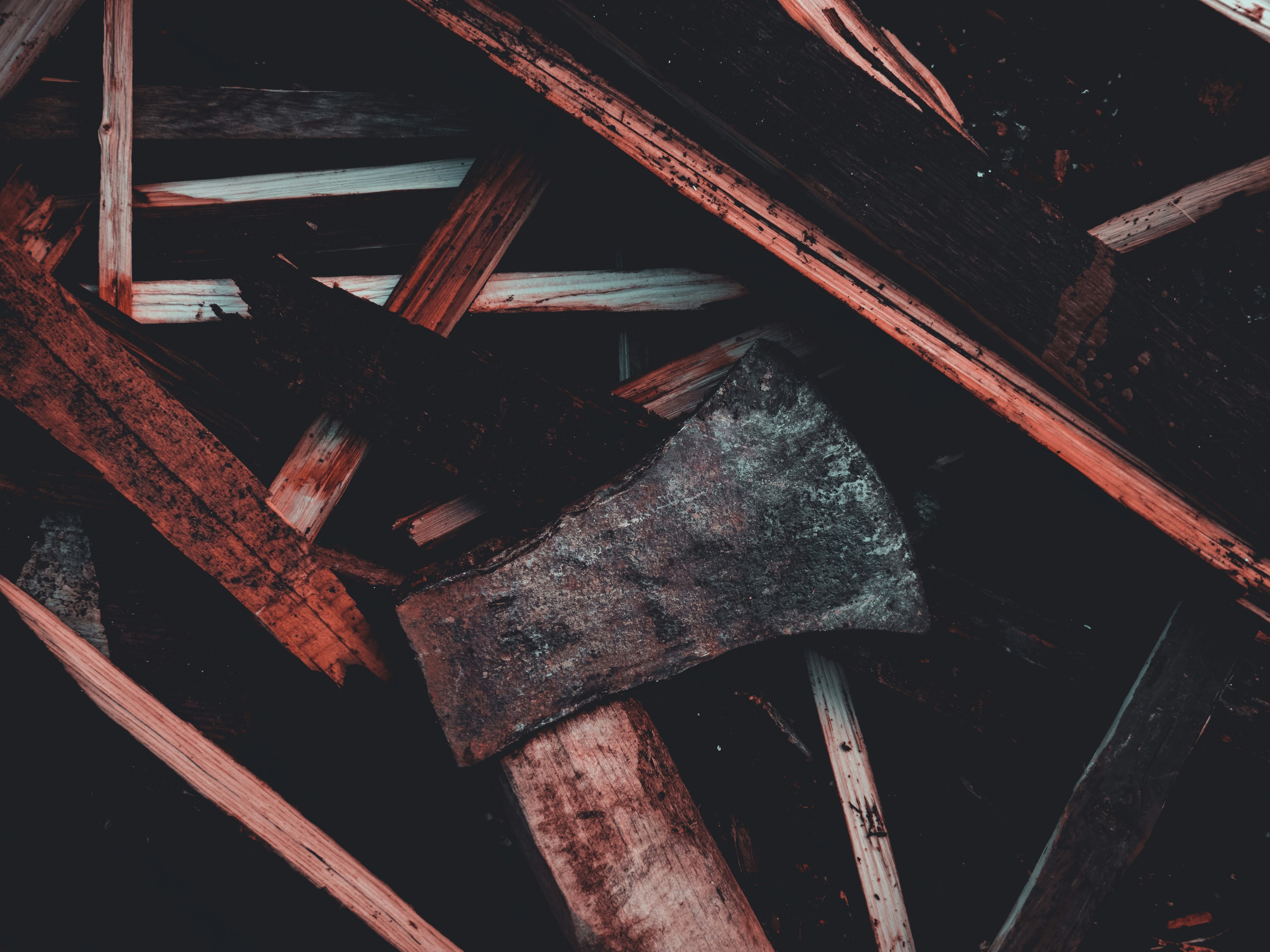 Weathered axes and wooden handles in a dark pile