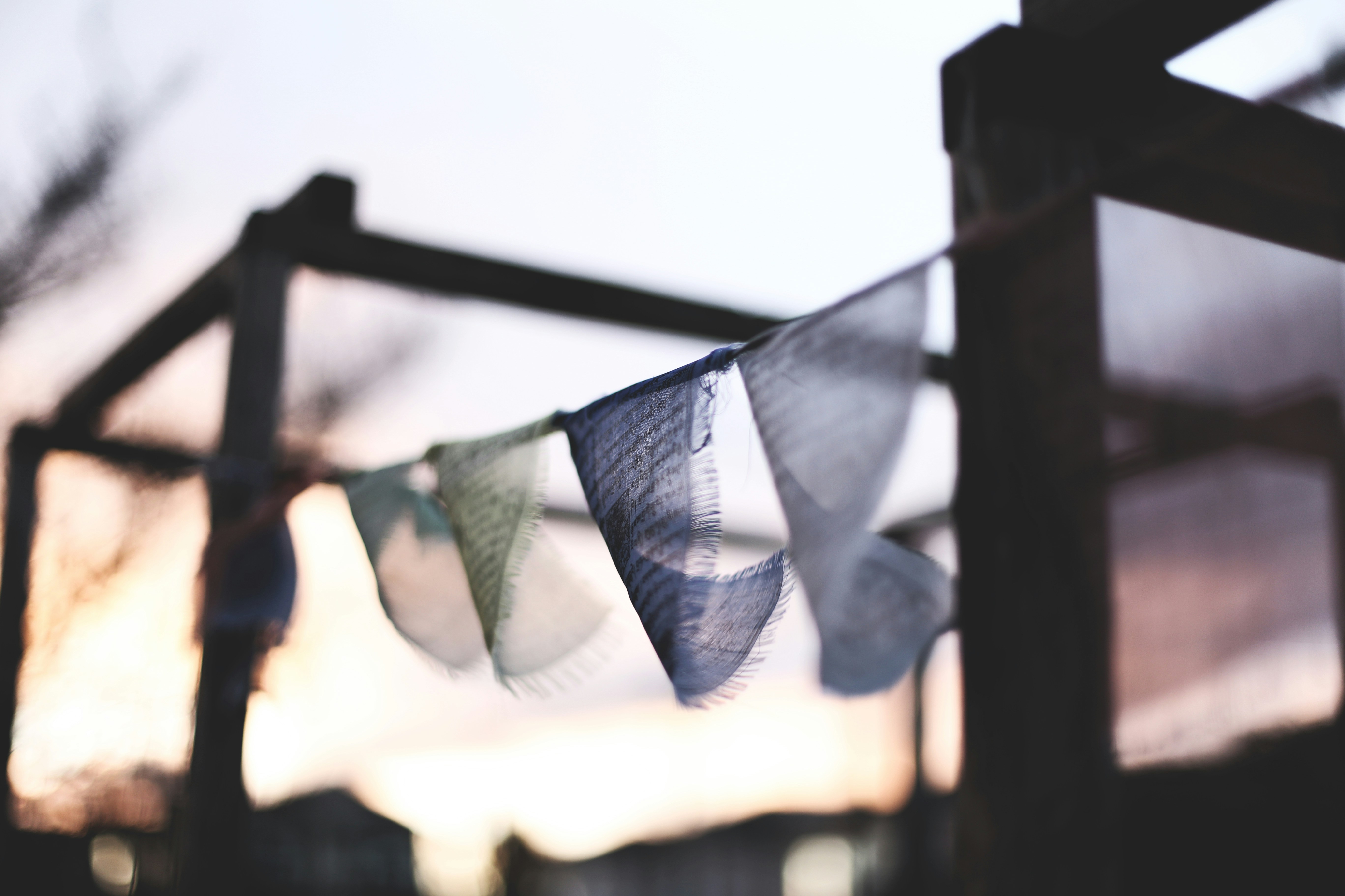 Drapeaux de prière tibétains suspendus en guirlande au coucher du soleil