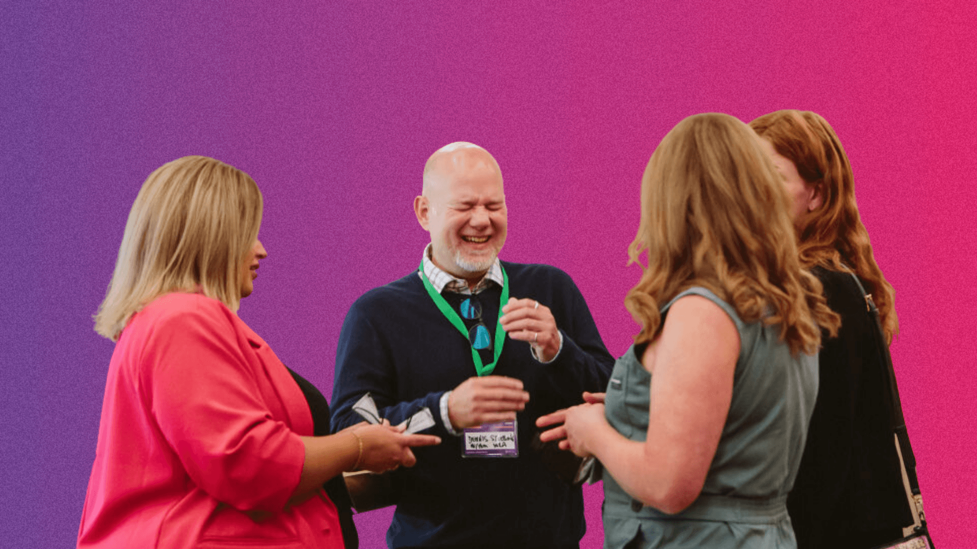 Four people engaged in a conversation, smiling and sharing ideas against a gradient pink background.