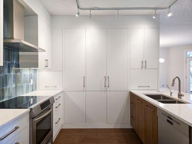 Image of Modern kitchen design with white and wood cabinets, stainless steel appliances, and KHD Homes layout design.
