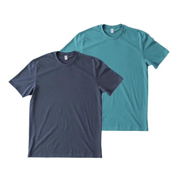 Two plain T-shirts, one in light pink and the other in dark blue, are layered flat on a surface, showcasing their simple round-neck design and soft, casual fabric.
