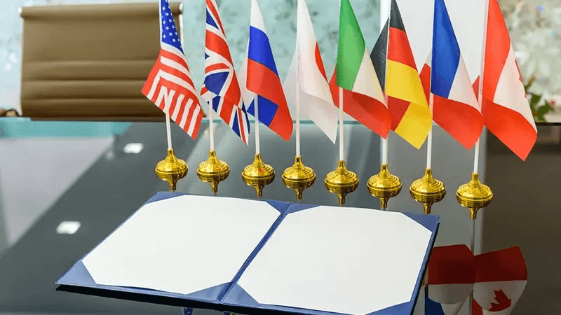 Man gestures during a meeting with laptops and plants