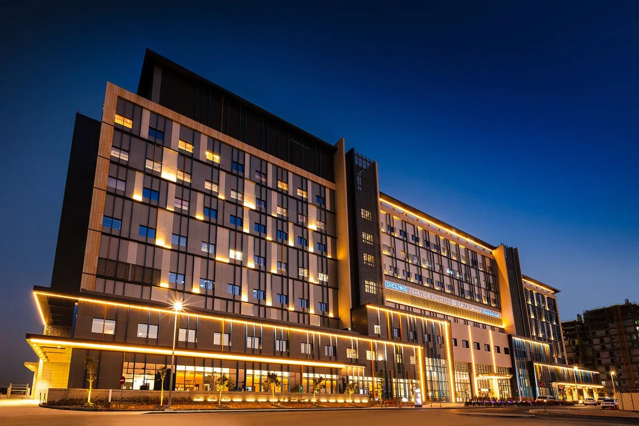 The modern Mediclinic Parkview Hospital at night, providing nearby healthcare for residents in Majan.