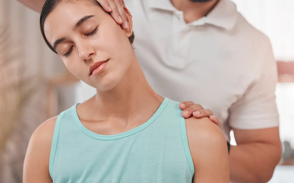 Chiropractor adjusting woman's neck. 