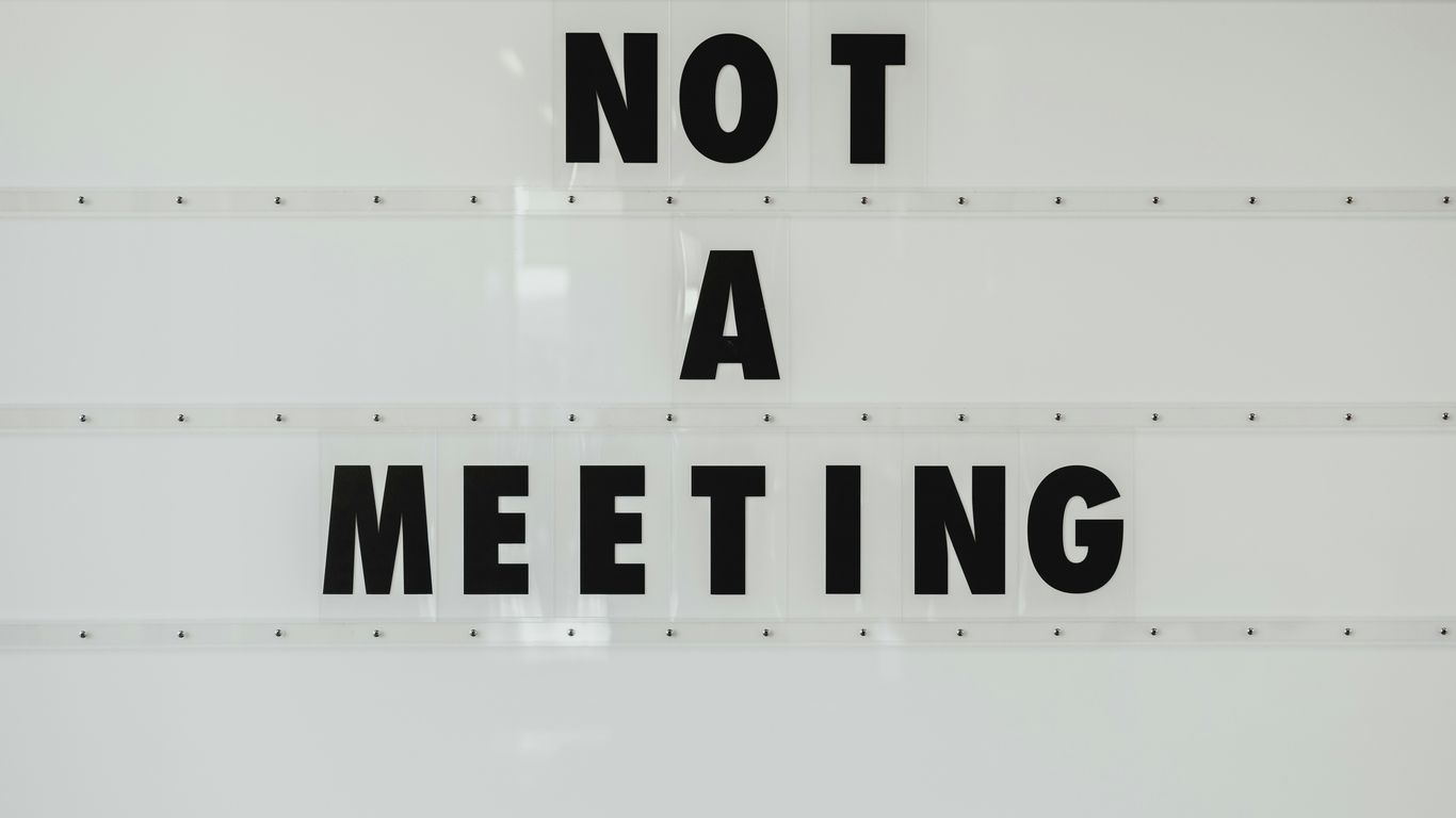 black note a meeting sign on wall