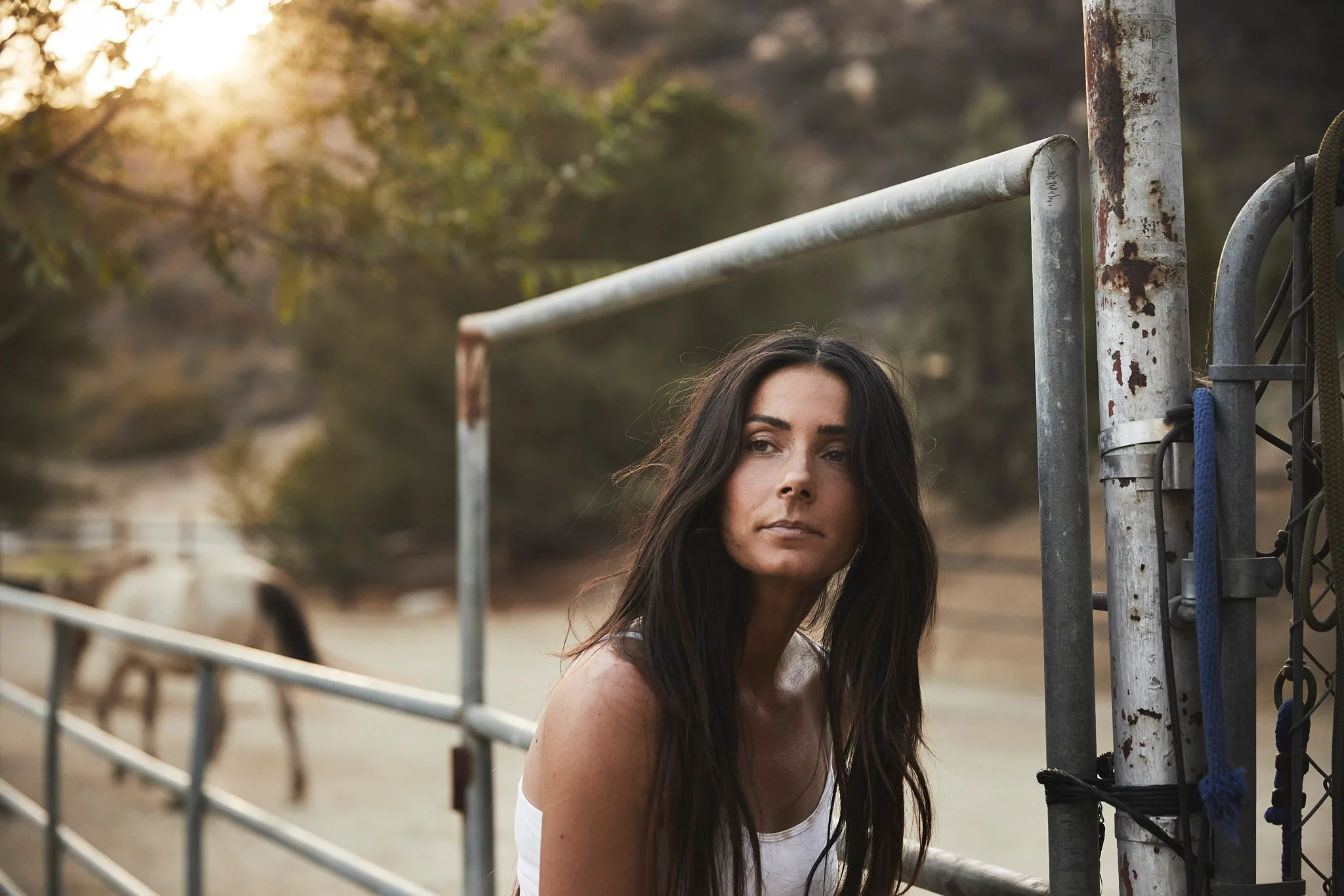 woman leaning against metal corral gate — Alex Saidac photography by Tom Kubik