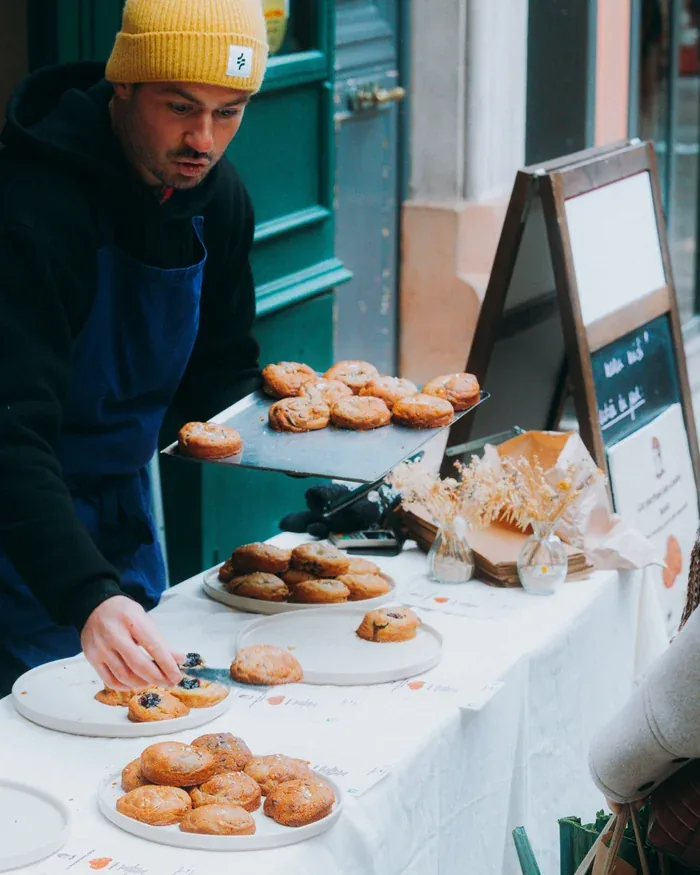 Raphaël, fondateur de Nanou Cookies, sur son stand de marché de cookies bio