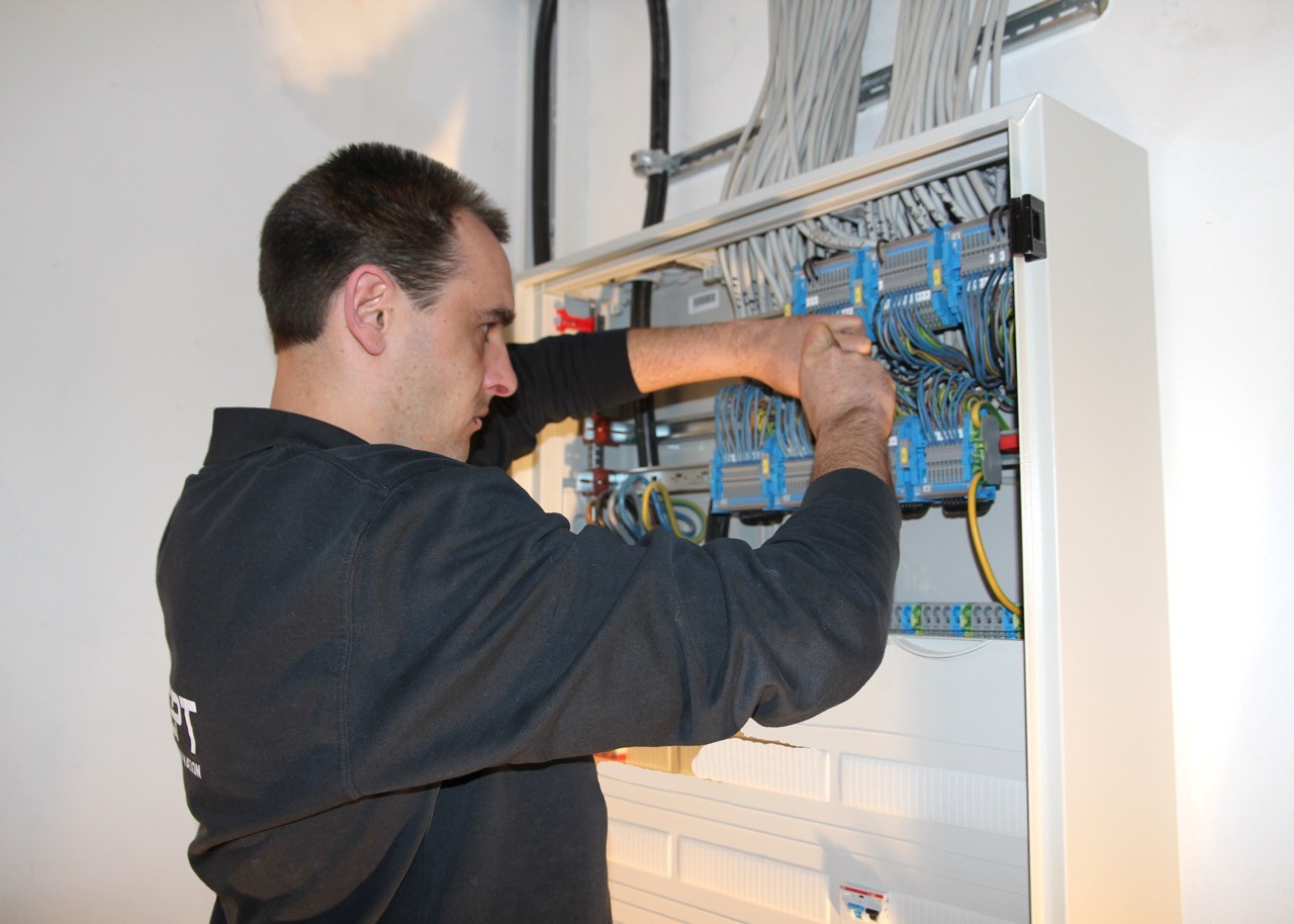 Elektriker arbeitet an Sicherungskasten. Installation und Wartung von Stromkabeln.